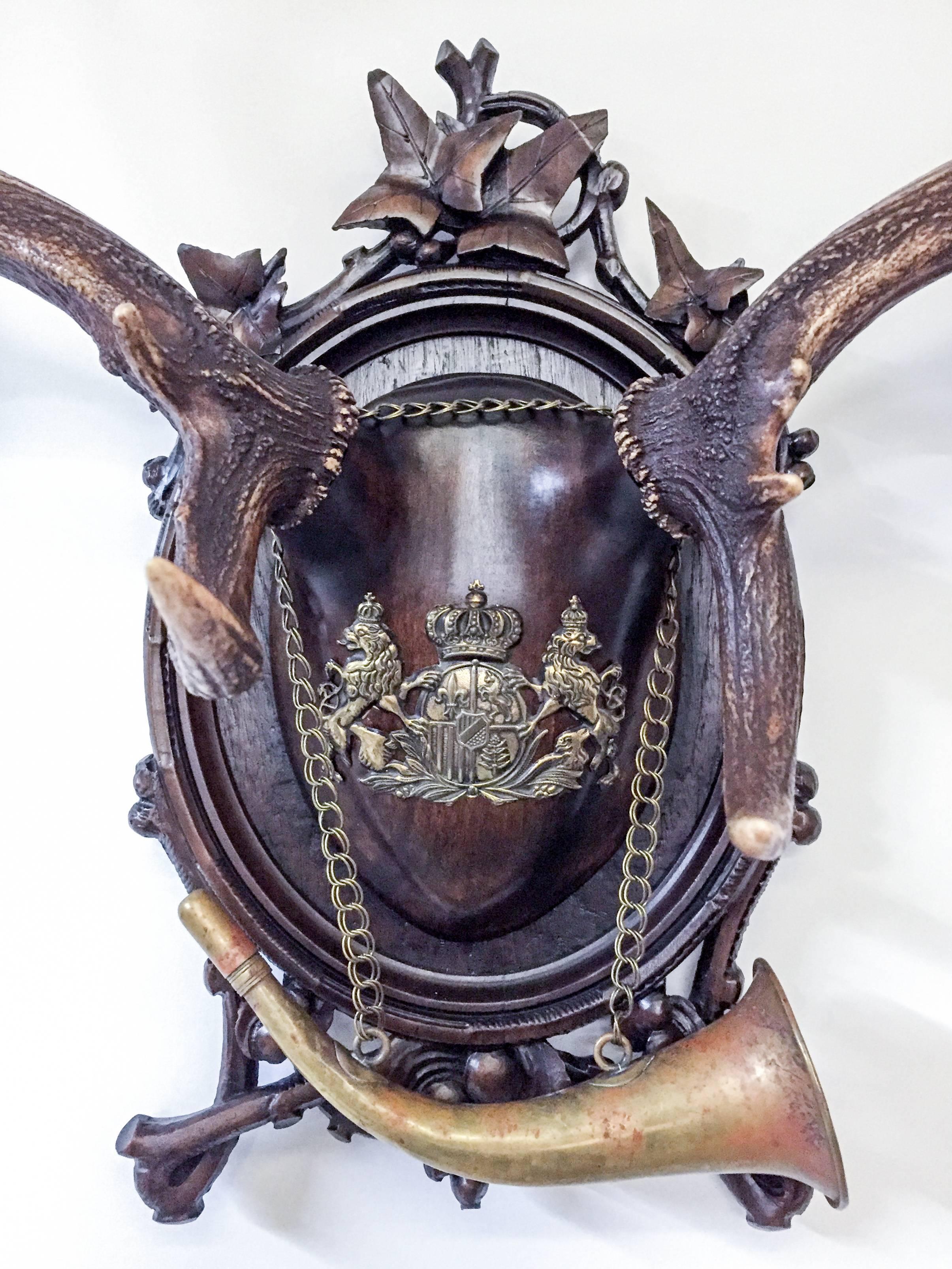 19th century hand-carved Black Forest wooden plaque and 19th century Habsburg fallow deer antlers. The wooden skull cap features a 19th century 