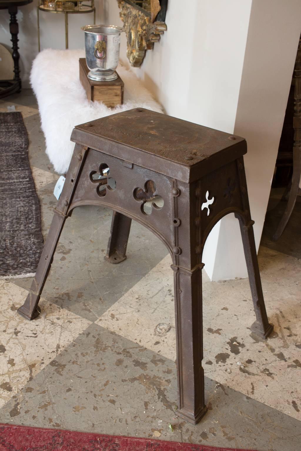This is a solid iron Gothic table we found on our most recent trip to France. The piece features pierced clover-shaped details and a wide, a-frame base. The piece measures 30.25