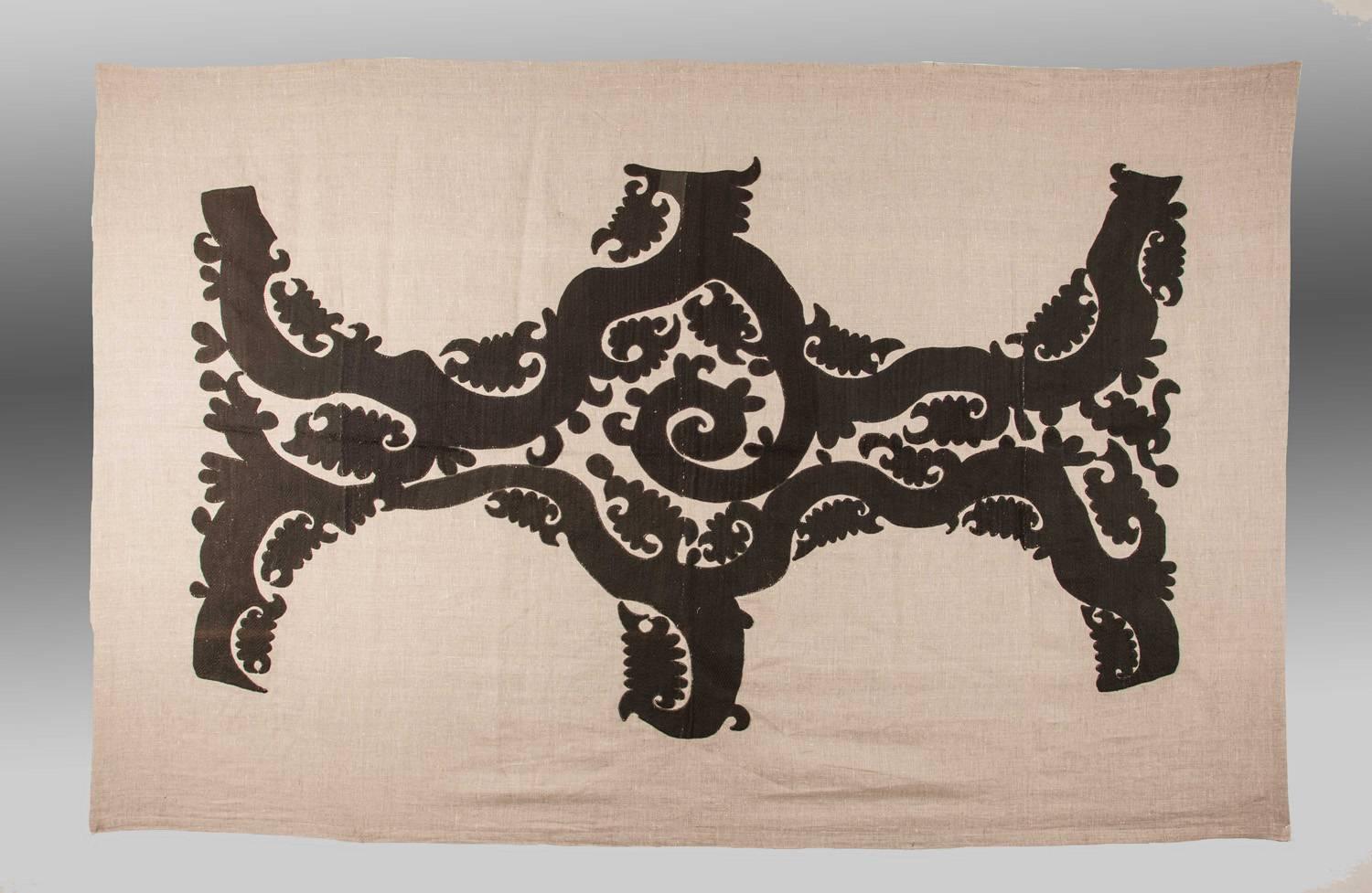 A unique textile consisting of vintage embroidery taken from an old Uzbek embroidery (from Samarkand area of Uzbekistan), cut-out and hand-sewn onto a large piece of linen material. 

This textile would make a dramatic wall hanging/head board