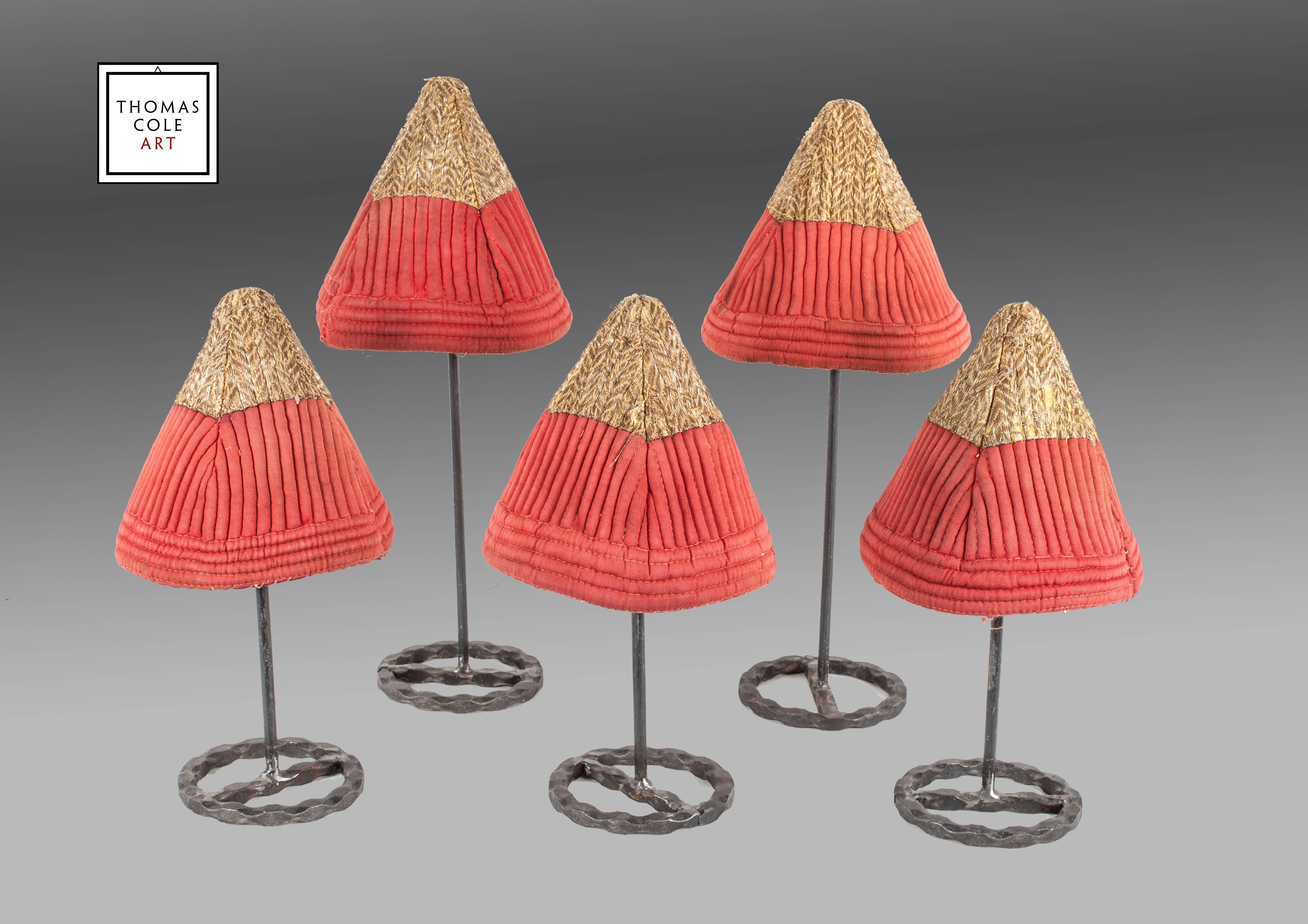 A rare and unusual group of hats from Central Asia, embroidered with a gold wrapped woolen yarn with the bottom half consisting of a red broadcloth, stitched to simulate a 'ribbing' effect.

The hats are thought to have been the property of
