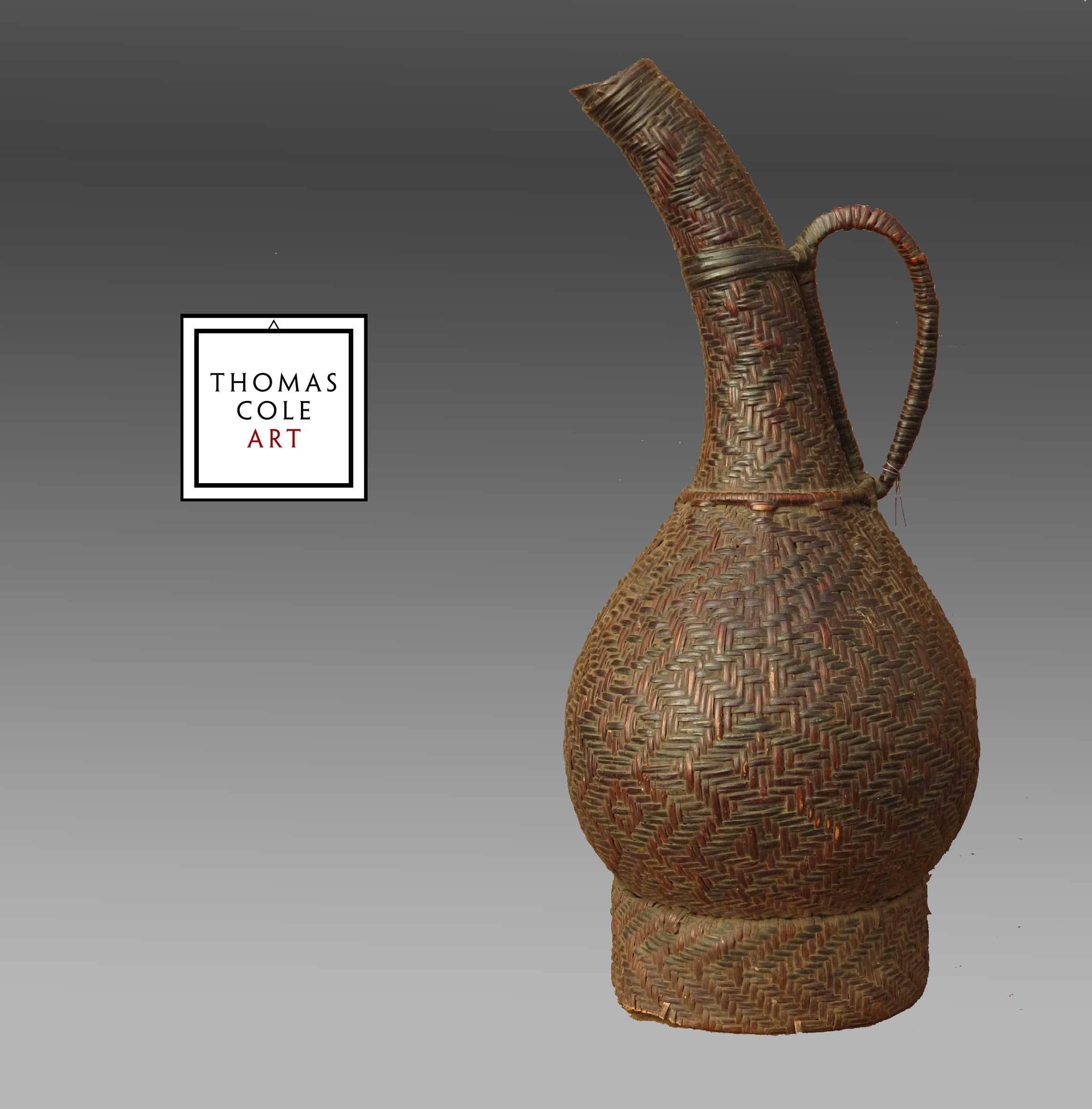 A gourd with woven basketry surrounding it, from the Kuba People of the Democratic Republic of the Congo. Measure: 11