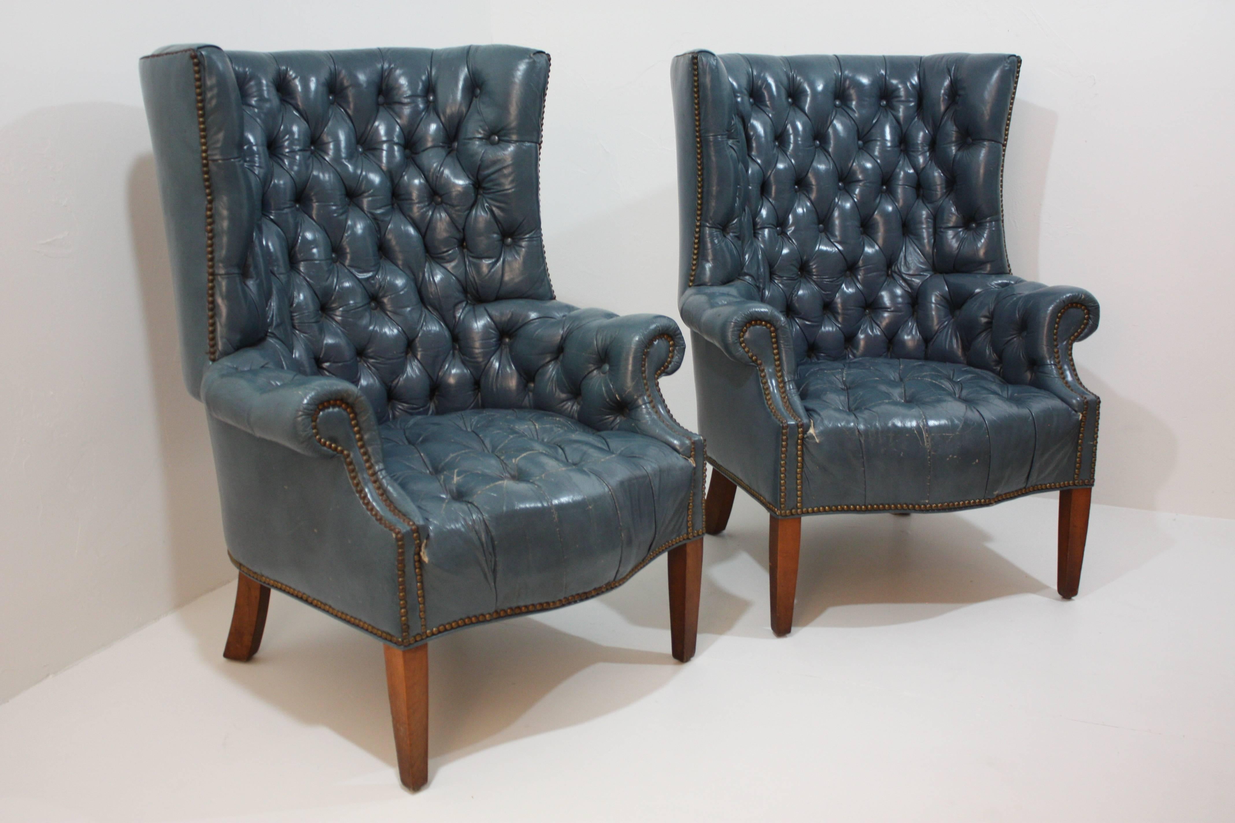 Wonderful leather tufted curved back chairs with brass tacks and wood legs.