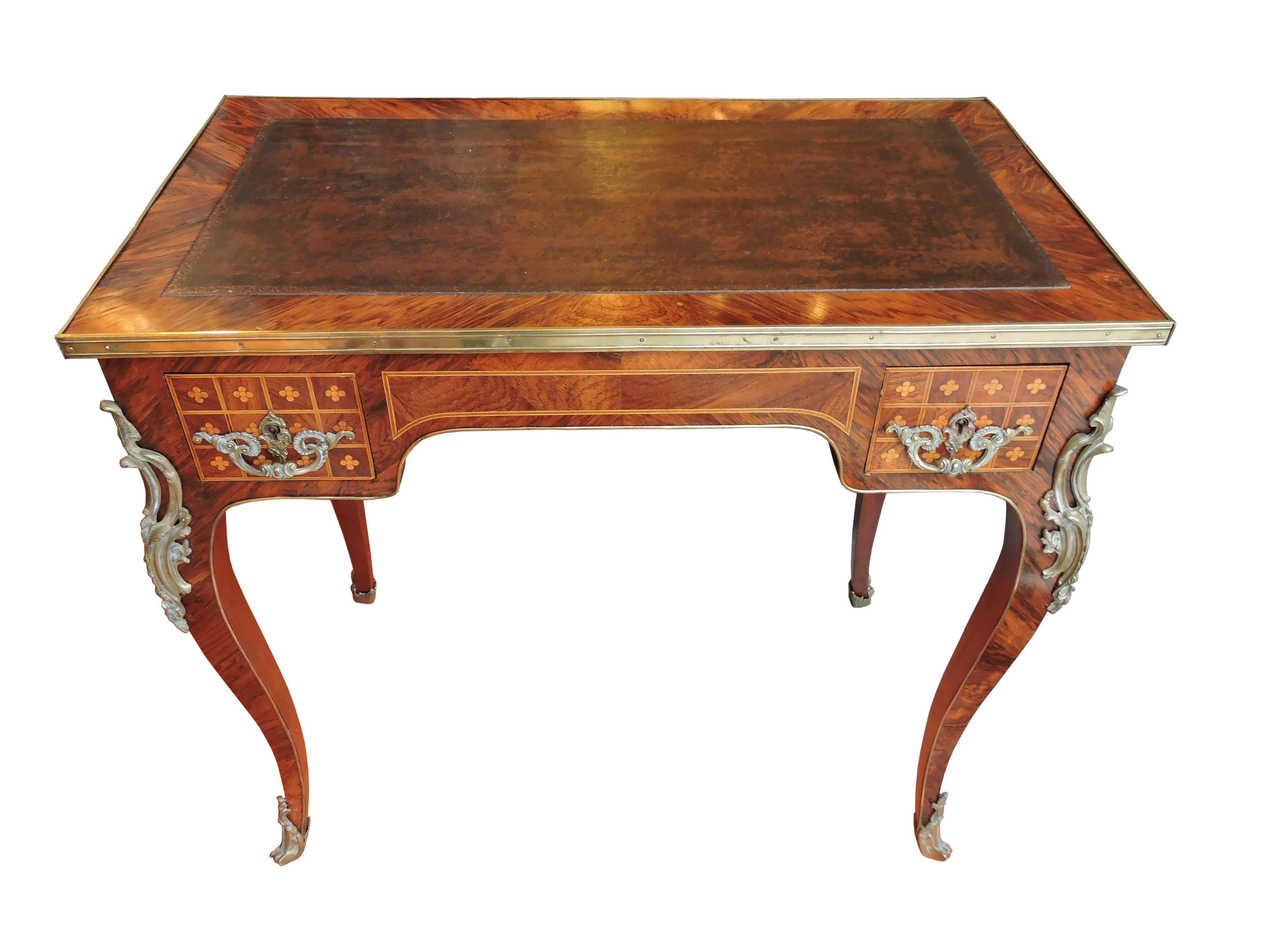 A beautiful European walnut French writing table with inlay Marquetry decoration on all four sides and can be displayed anywhere in a room. Bronze mounts on the feet, legs, trim and handles. It has two small drawers on each side. Very nice quality.