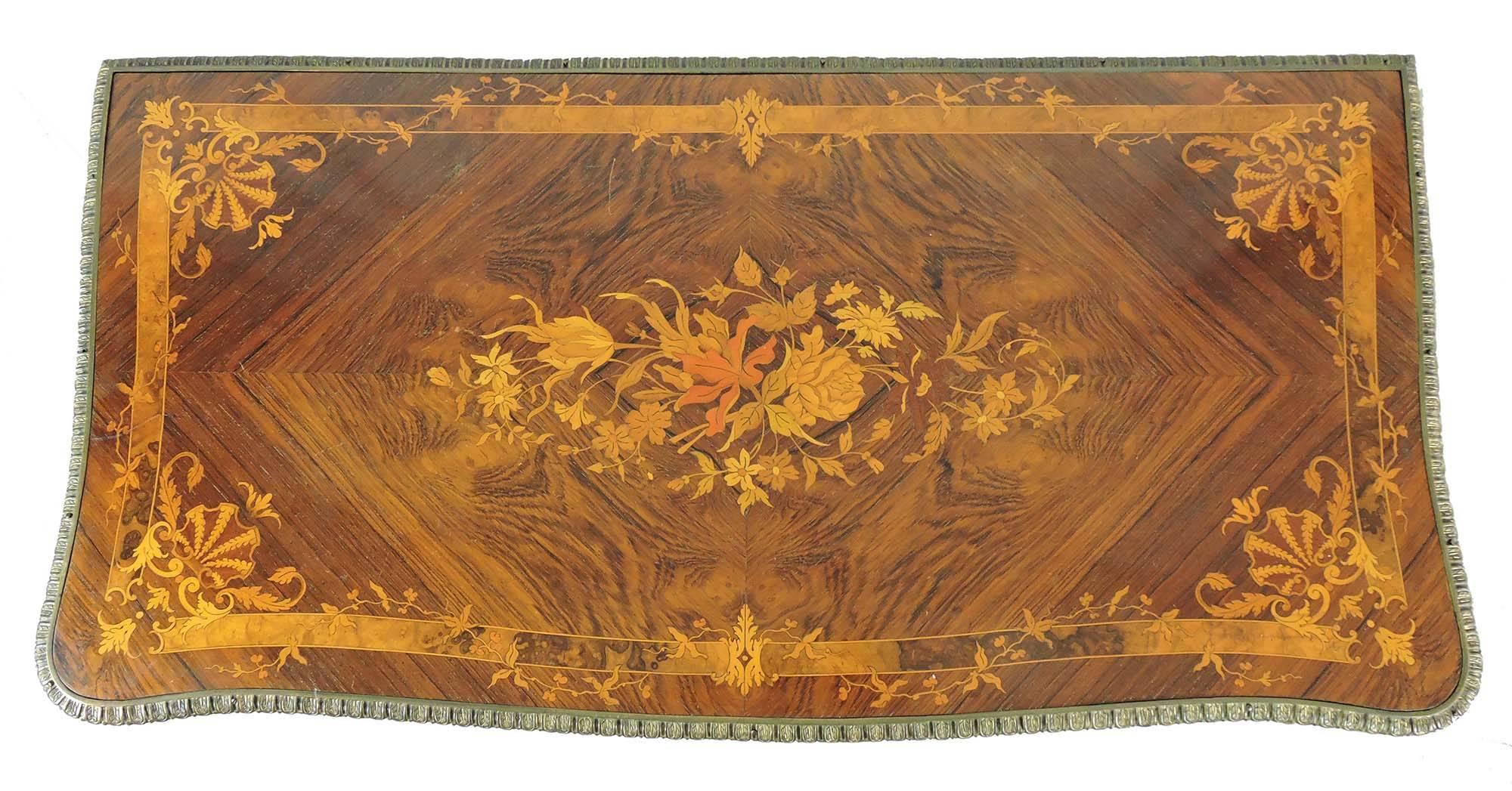 We offer a French Louis XV style European walnut games table on cabriole legs, with gilt bronze mounts. The top and side panels are inlaid with fine floral and scrollwork marquetry in satinwood, fruitwoods, and burled walnut throughout a European