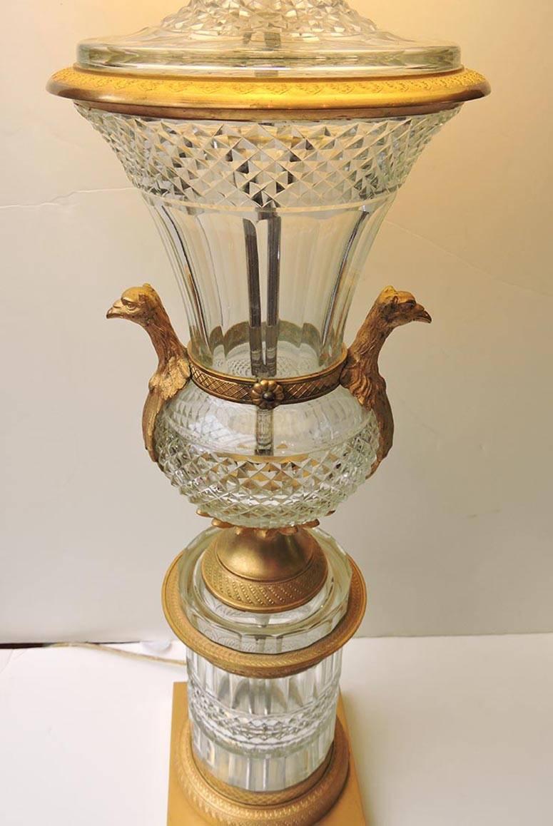 A lovely pair of tall heavy cut crystal lamps with gilt bronze hardware. The bronze mounts include eagle head handles. The overall design has an Imperial Russian influence.

Nice sharp crystal points and overall beautiful quality.

Body of lamp
