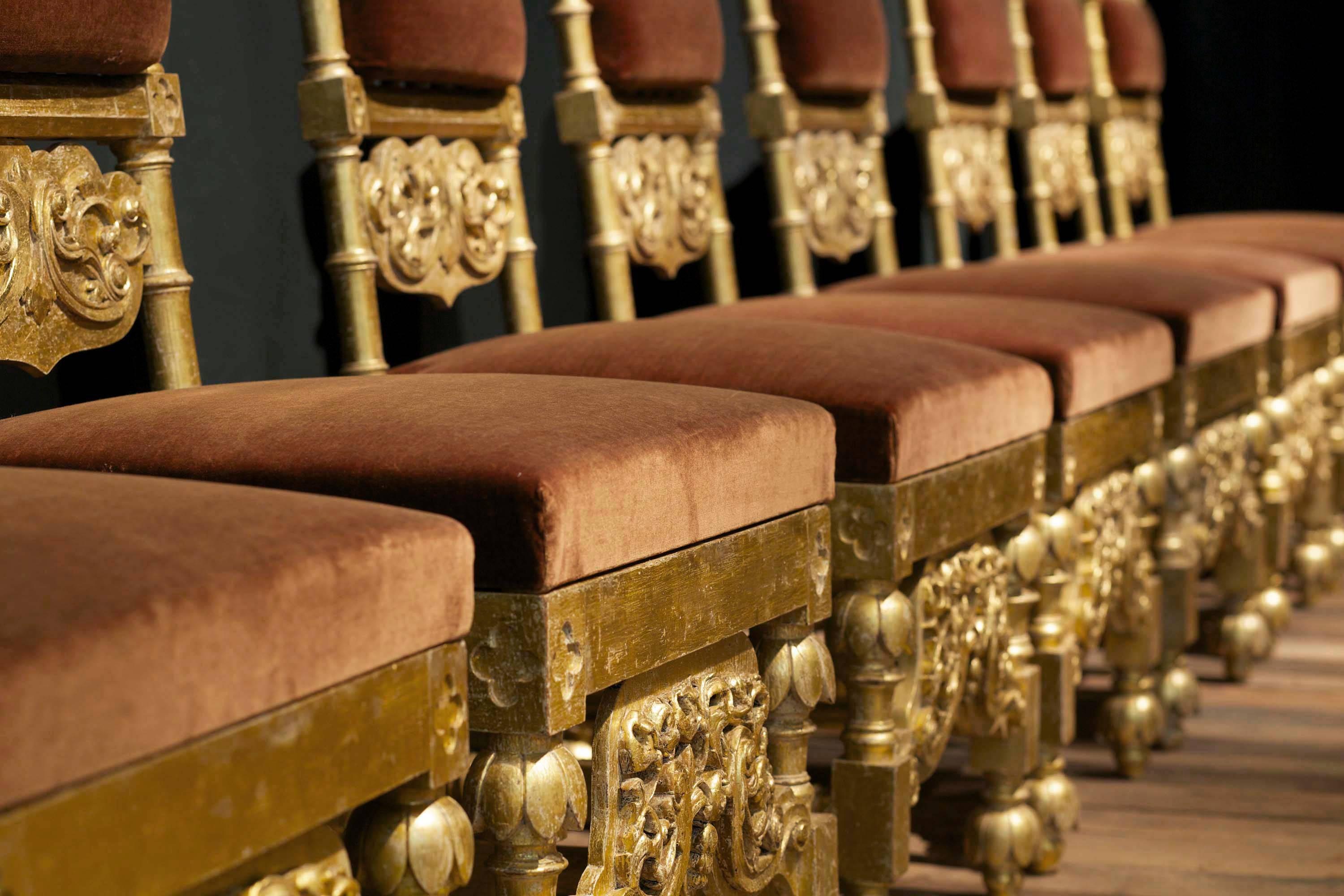 Elizabethan Revival parcel-gilt chairs, each with ring-turned top rail carved with quatrefoils, the horizontal strapwork-carved splat above a caned seat and similarly carved front stretcher, on turned legs with lotus-caps and with box stretchers,