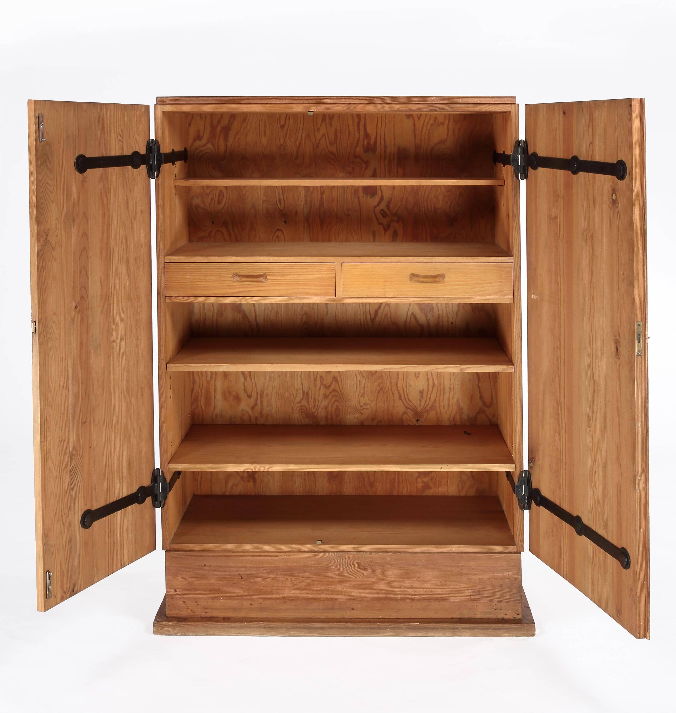 Designed by Axel Einar Hjorth for Nordiska Kompaniet 

Stained Swedish Pine, the shelved interior with two drawers. 

Sweden, circa 1932.