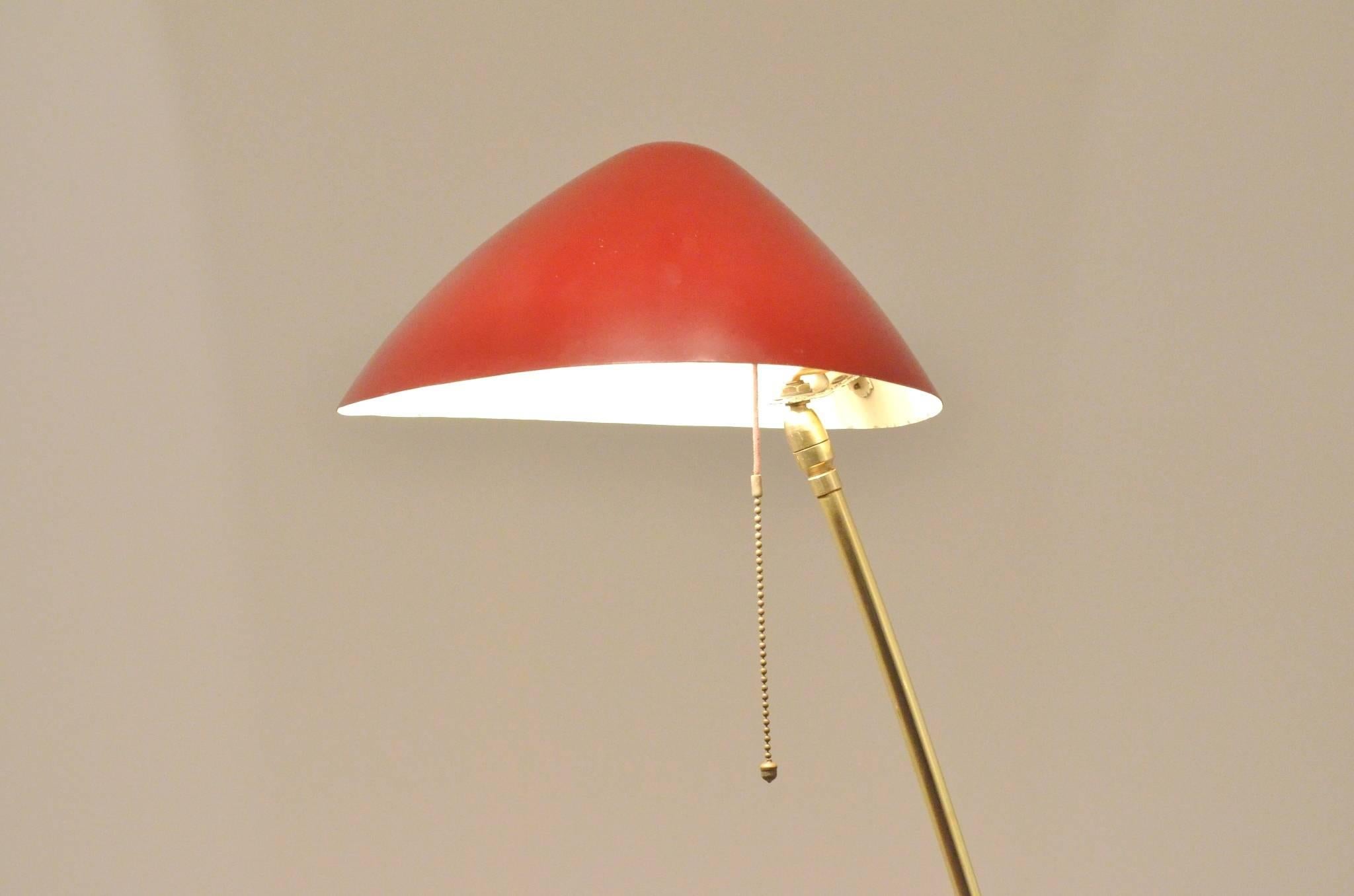 Elegant Minimalist floor lamp with a delicate brass stand with a red painted lamp shade and original brass chain light switch.