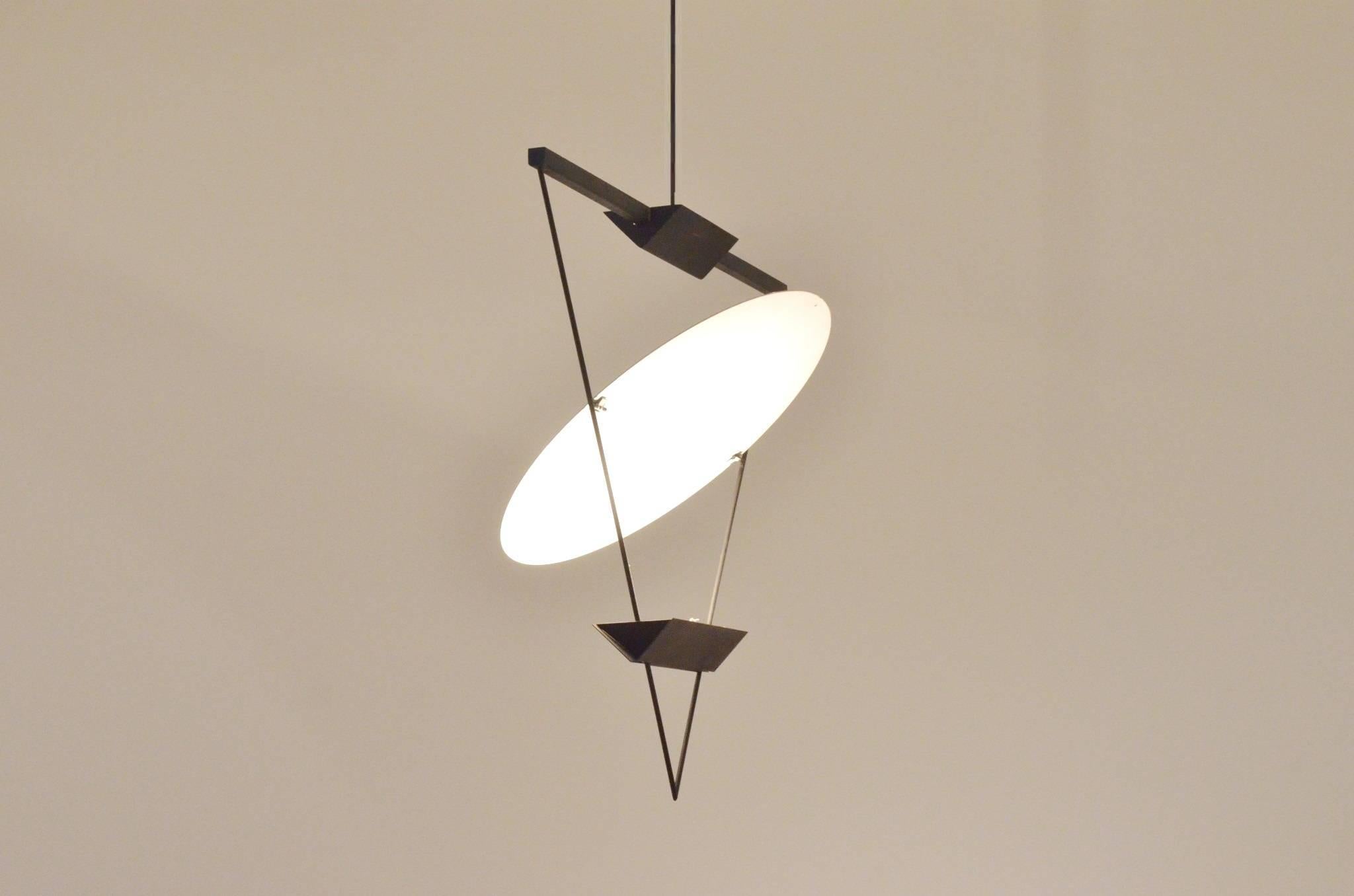 A rare triangle hanging light by Mario Botta for Artemide produced in Italy during the 1980s.
The lamp has two halogen up lighters and large round white reflector.
Geometrical shapes with a study in geometry and reflection.