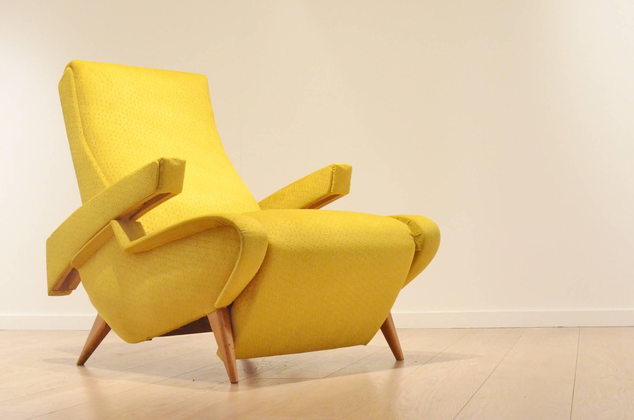 Unique Italian mustard yellow easy chair in the manner of Augusto Romano, and dating from the end 1940s. It converts into a daybed as well as adjustable arm rests. Very futuristic and streamline design with sculpted wooden legs. 
The textile of the