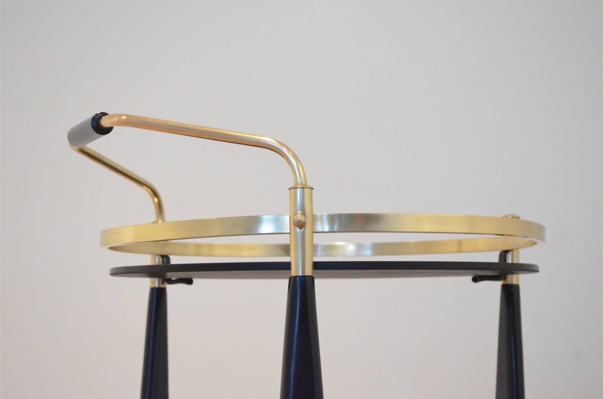 Nice Mid-Century serving trolley originating from France in the manner of Maison Jansen, black lacquered wood elements matched with brass structure. Original black opaline glass tops.