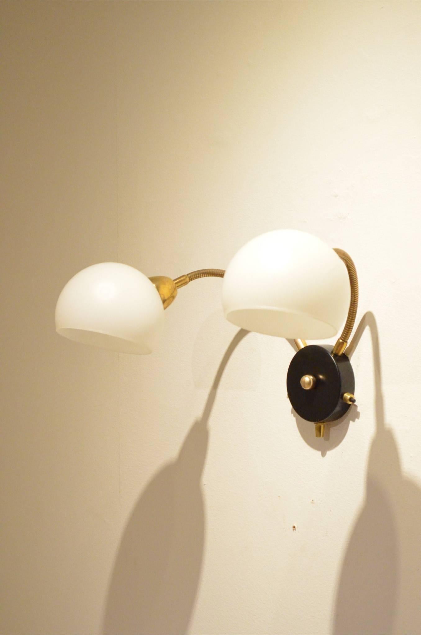 Mid-Century French design wall sconce, black painted round base matched with brass flexibles.