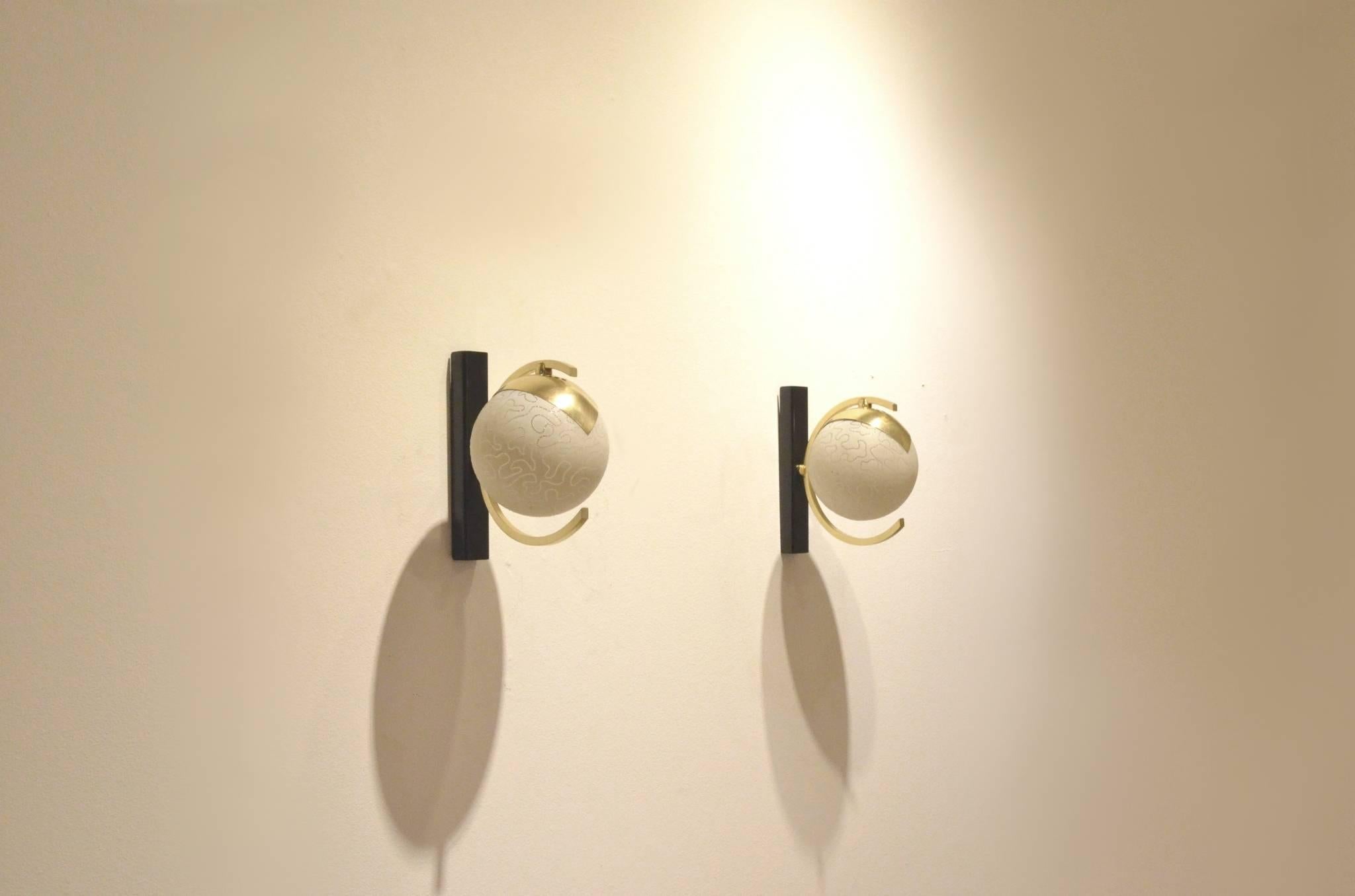 Set of two small sized midcentury French wall sconces from Maison Arlus, etched glass ball diffusers matched with brass and black painted metal bases.