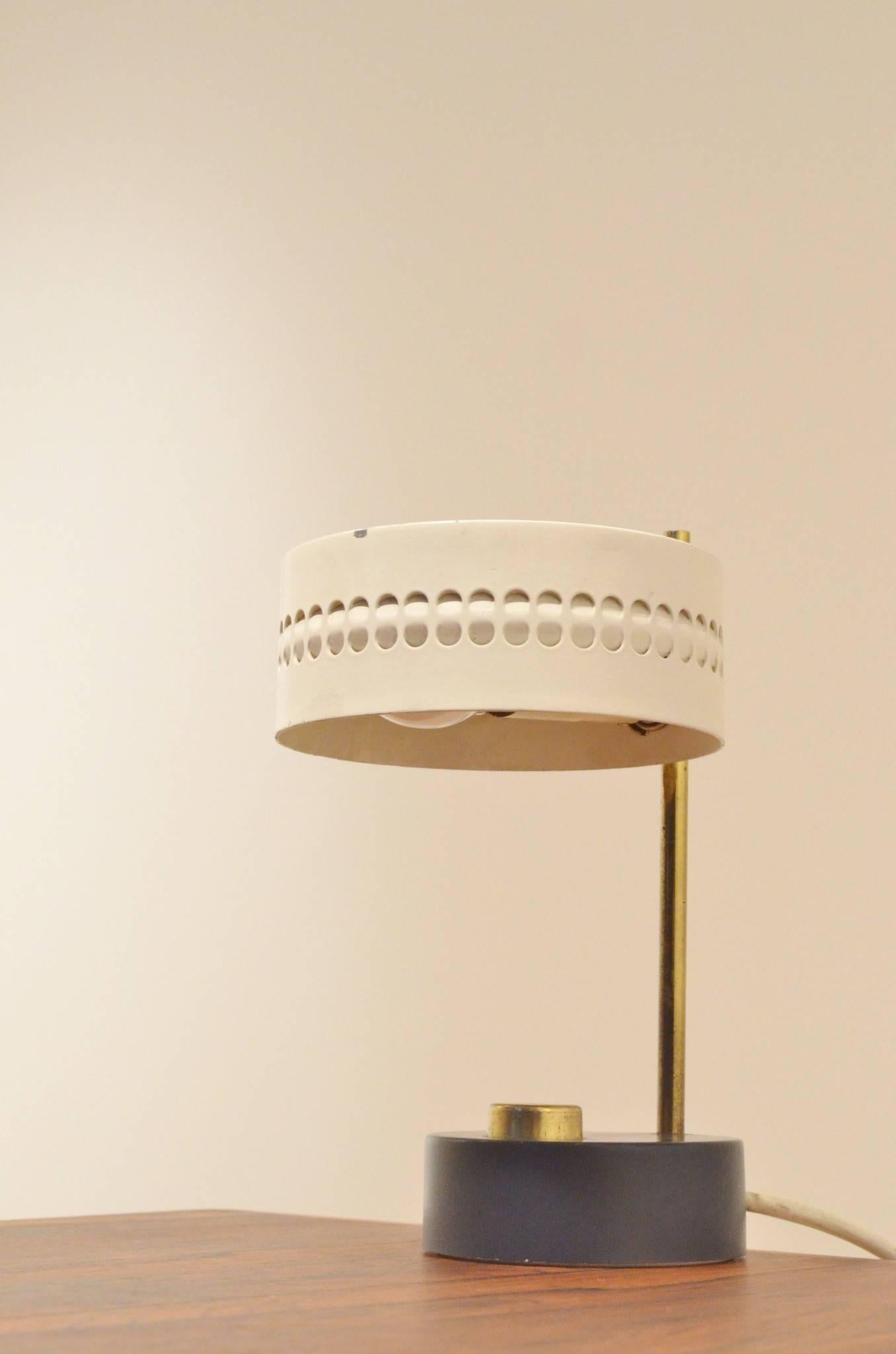 Small table lamp attributed to Mathieu Mategot with perforated white/grey painted metal, the stand and switch are made in brass and the base is in black painted metal.
    
