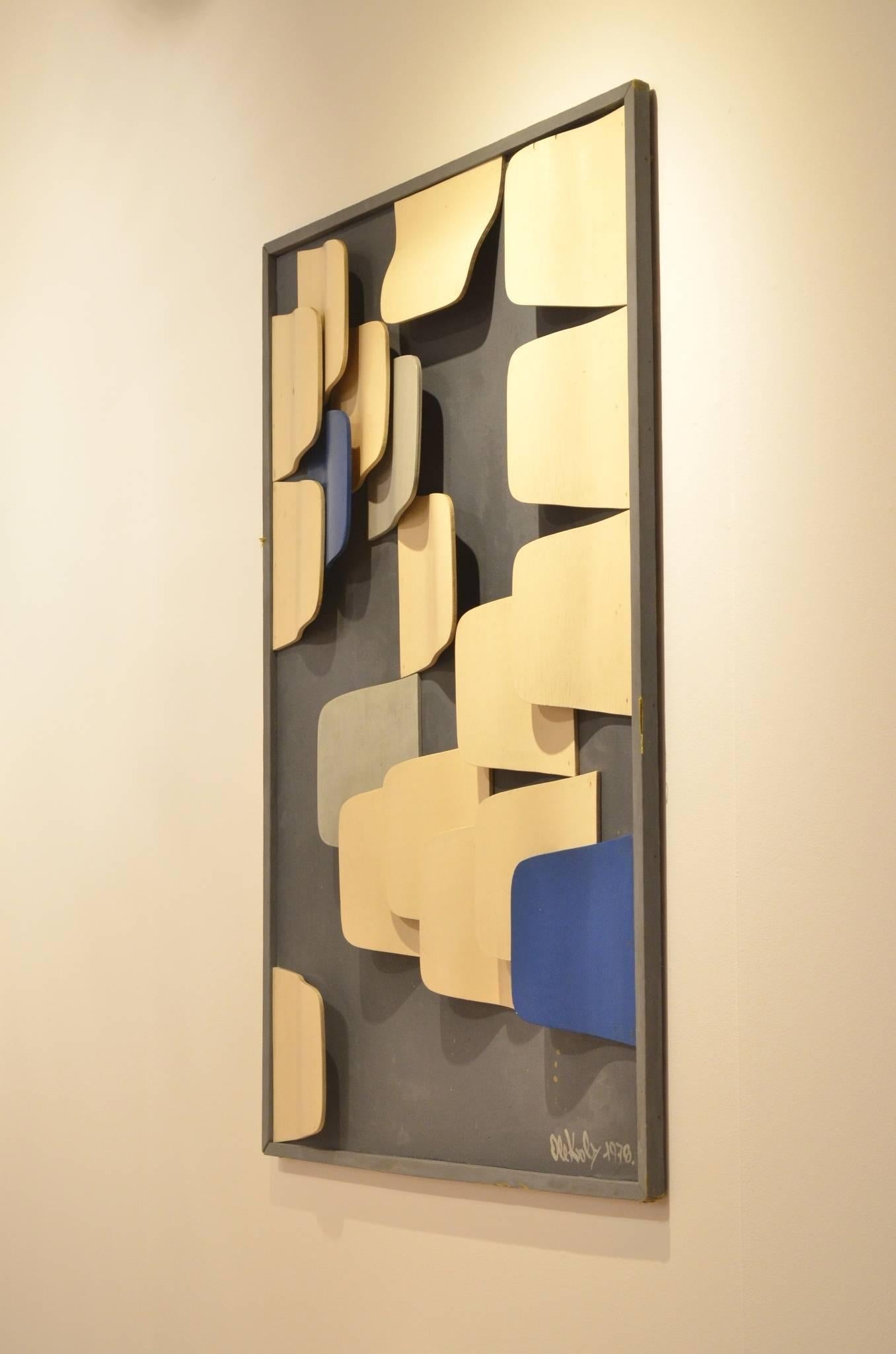 Structural Op Art inspired art work created in 1976.

It is composed of white, gray and Klein blue painted curved wooden slats. The slats are superimposed on one another, with the alternating colors creating texture and depth. 

The piece is