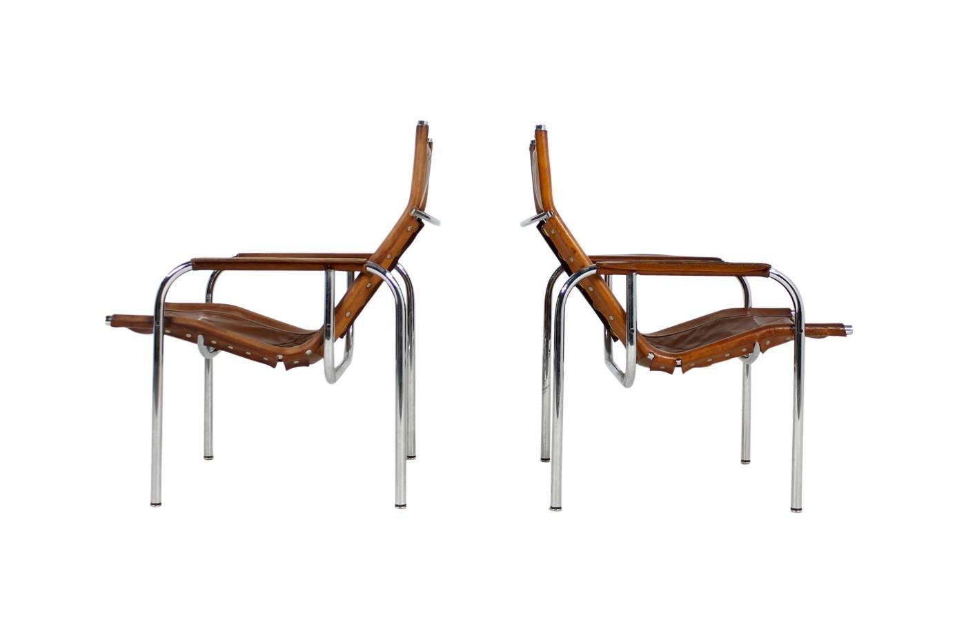Beautiful pair of early, vintage 1970s lounge chairs by Hans Eichenberger for Straessle, Switzerland, Mod. HE. Good vintage condition, fantastic and unique patina on the cognac leather, chrome in very good condition.