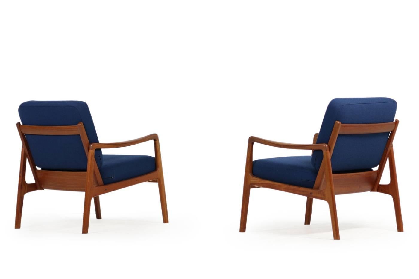 Beautiful and rare pair of Ole Wanscher Mod. 109 teak easy chairs for France & Son Denmark. Very good condition, new upholstery and covered with new dark blue woven high quality fabric.
 