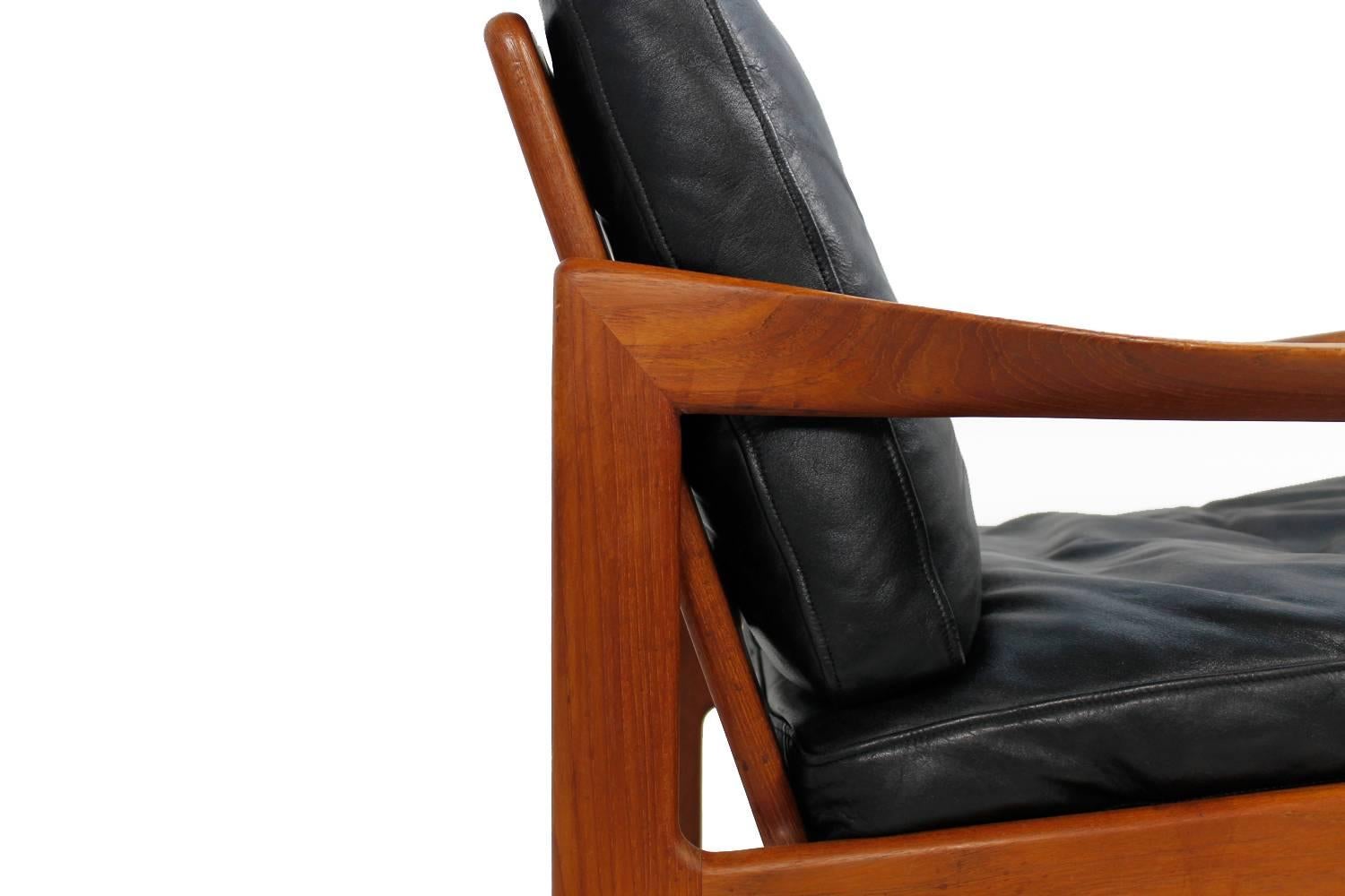 Beautiful 1960s pair of Wikkelso lounge chairs, teak and black leather, down filling, fantastic condition. Produced by Niels Eilersen Denmark.