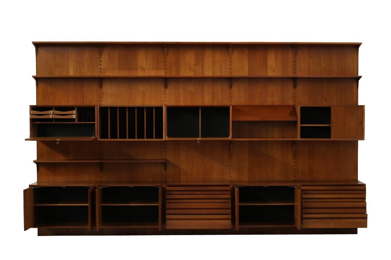 Beautiful 1960s Poul Cadovius Royal teak wall unit by Cado, Made in Denmark.
Fantastic condition, very large, measures: ca. 400 x 235 x 48cm
Five cabinets ca. 80x46x52cm (W x D x H)
Four cabinets ca. 80x38x42cm (W x D x H)
12 shelves ca.