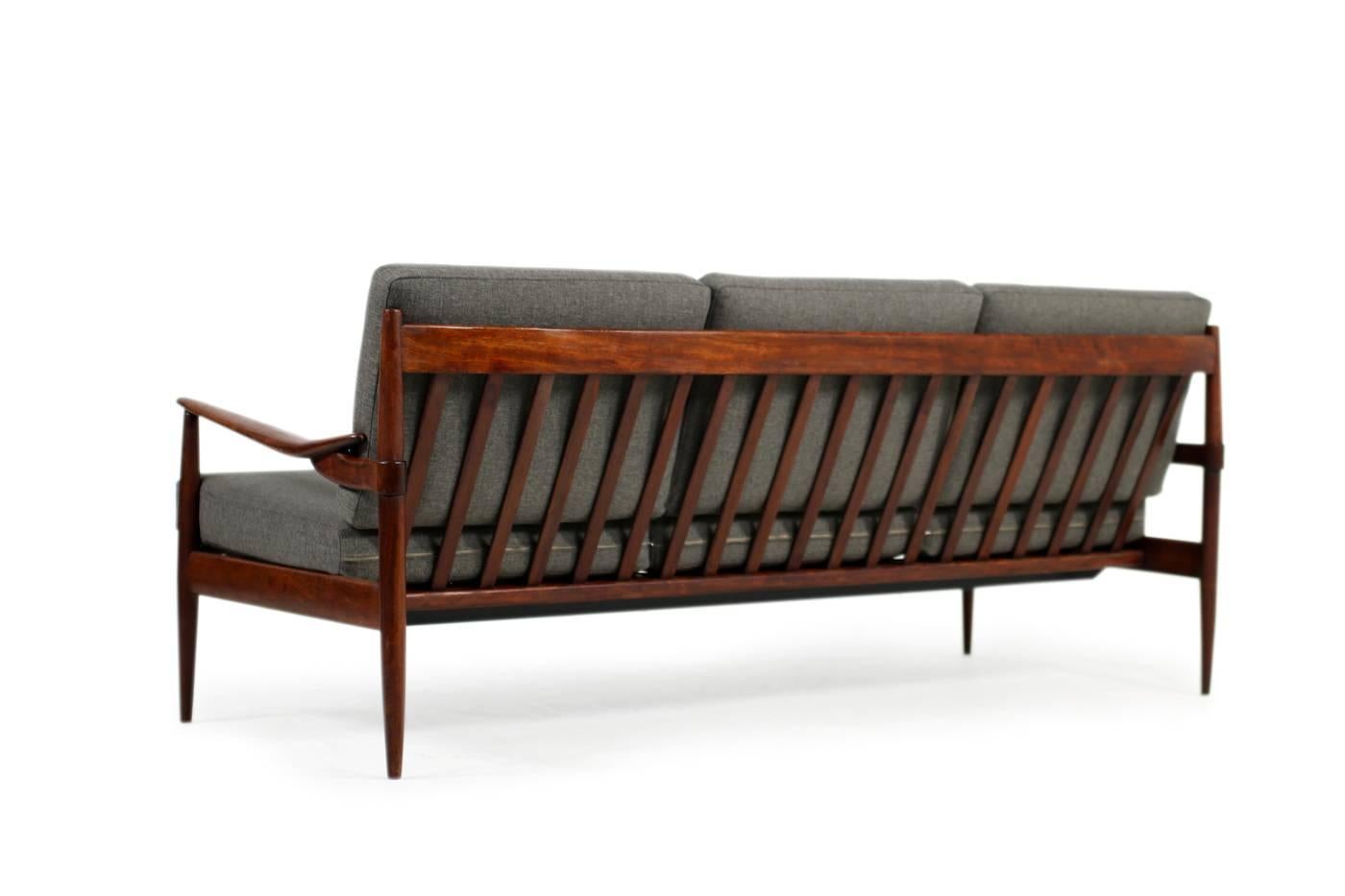 Rare 1960s Mid-Century Modern sofa, in fantastic condition. New upholstery and covered with new woven fabric, freestanding. Beautiful sculptural and organic details, especially the armrests. The wood is mahogany but stained in a rosewood look, very