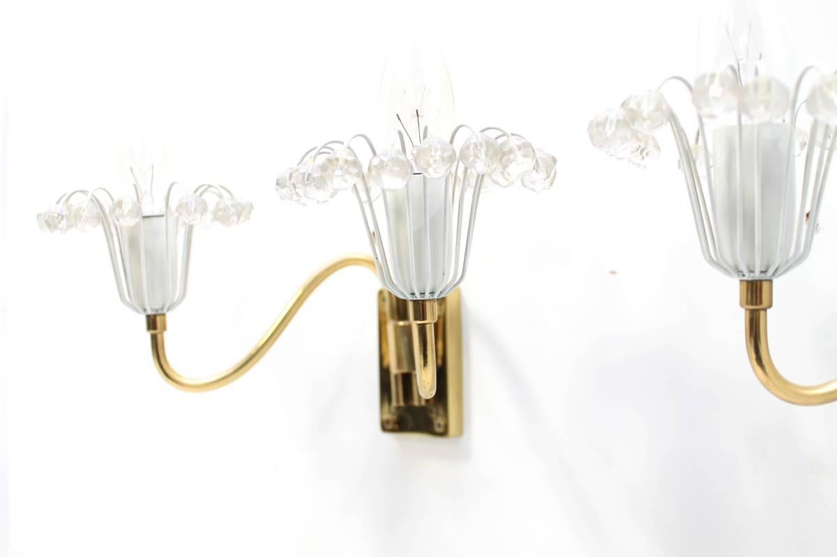 Beautiful pair of 1960s Emil Stejnar brass and crystal glass sconces, Rupert Nikoll, Vienna. Glass parts and the brass base in very good condition. Each light for two small bulbs up to 45W each. They can be used in Europe, the US and Asia.