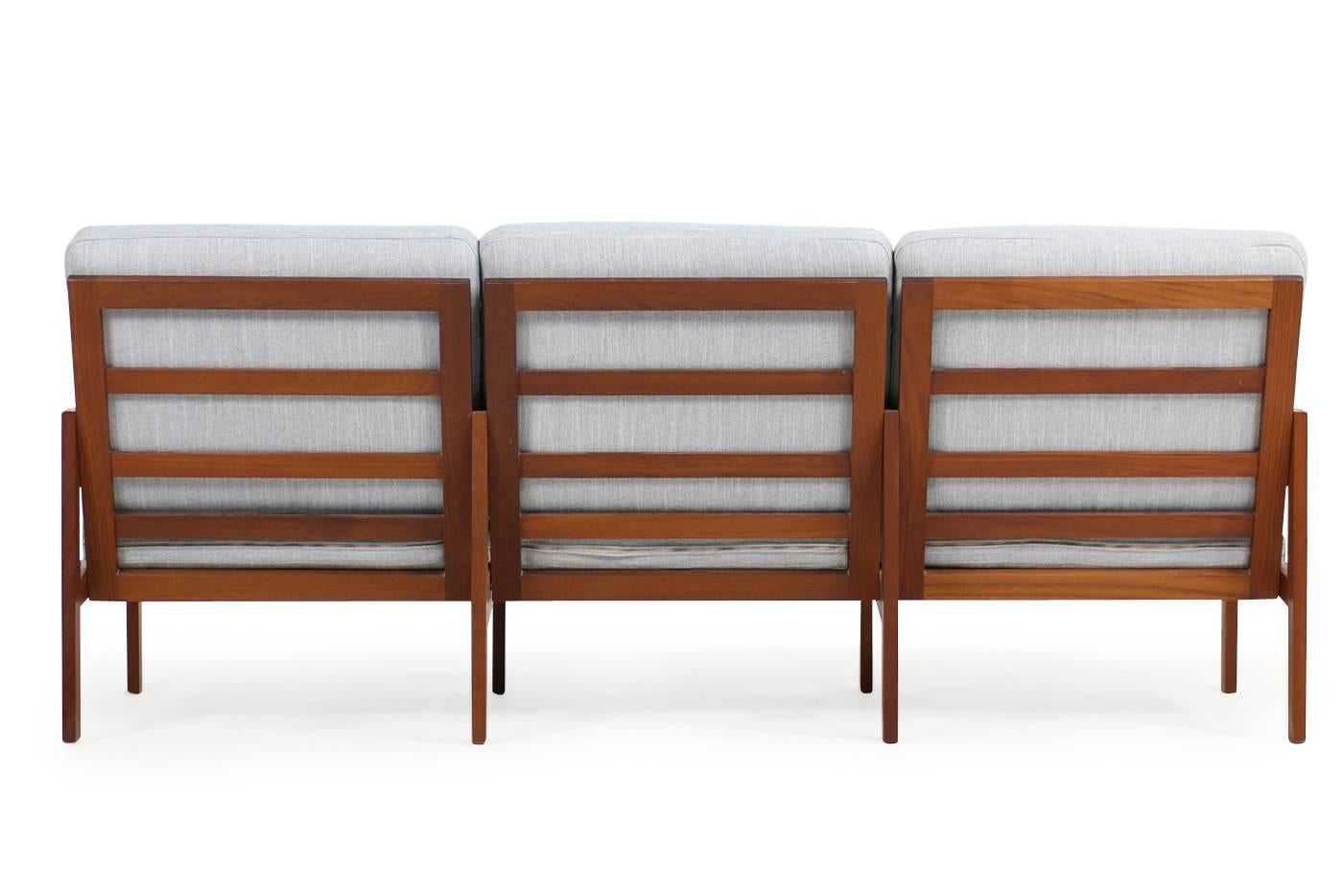 Beautiful 1960s Teak Sofa, new upholstery and covered with a beautiful light grey woven fabric.
Model Capella by Illum Wikkelsø for Niels Eilersen, Denmark. Solid teakwood base also in a very good condition, we have a pair of matching chairs