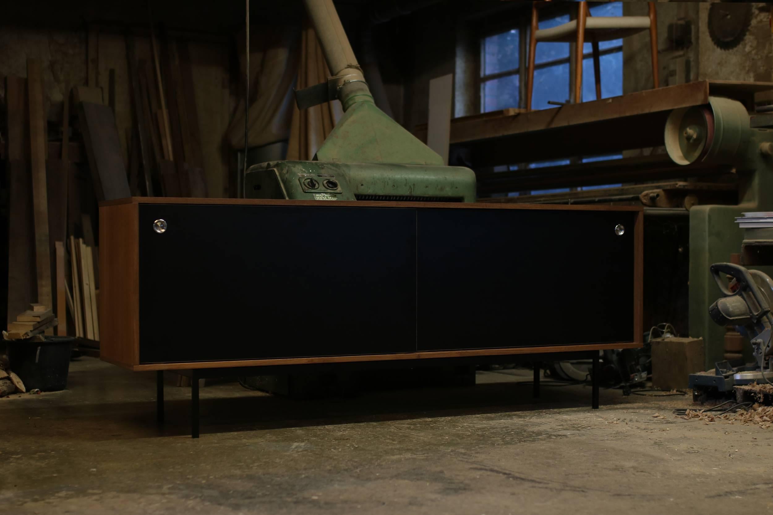 Beautiful teak sideboard, freestanding, made in Germany, design by Nathan Lindberg (Nathan Lindberg Design)
Black HPL (Formica) sliding doors with stainless steel door handles, iron base powder coated in black.
Best condition, the sideboard was