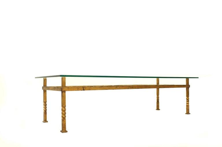 Beautiful and rare mid century iron table, gold plated with unique patina, tabletop made of glass. Authentic condition, heavy weight and a beautiful form.