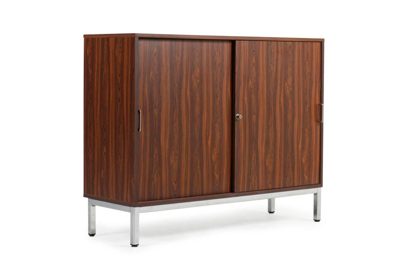 Great 1970s cabinet, two sliding doors, rosewood formica, artificially veneer, metal base in chrome, adjustable shelves, metal handles, extremely good condition.
