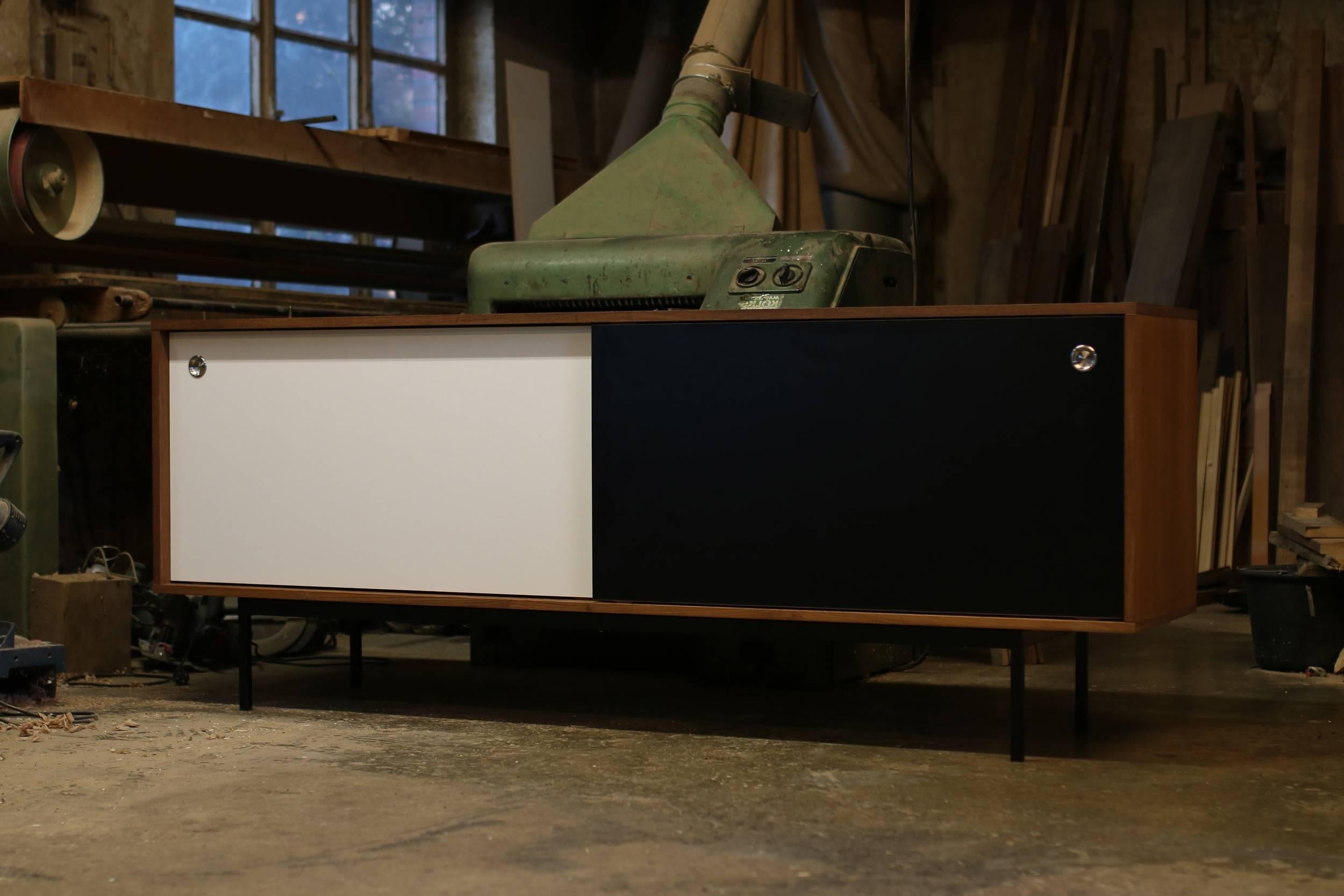 Beautiful teak sideboard, freestanding, made in Germany, design by Nathan Lindberg (Nathan Lindberg Design)
Black and White HPL (Formica) sliding doors with stainless steel door handles, iron base powder coated in black.
Best condition, the