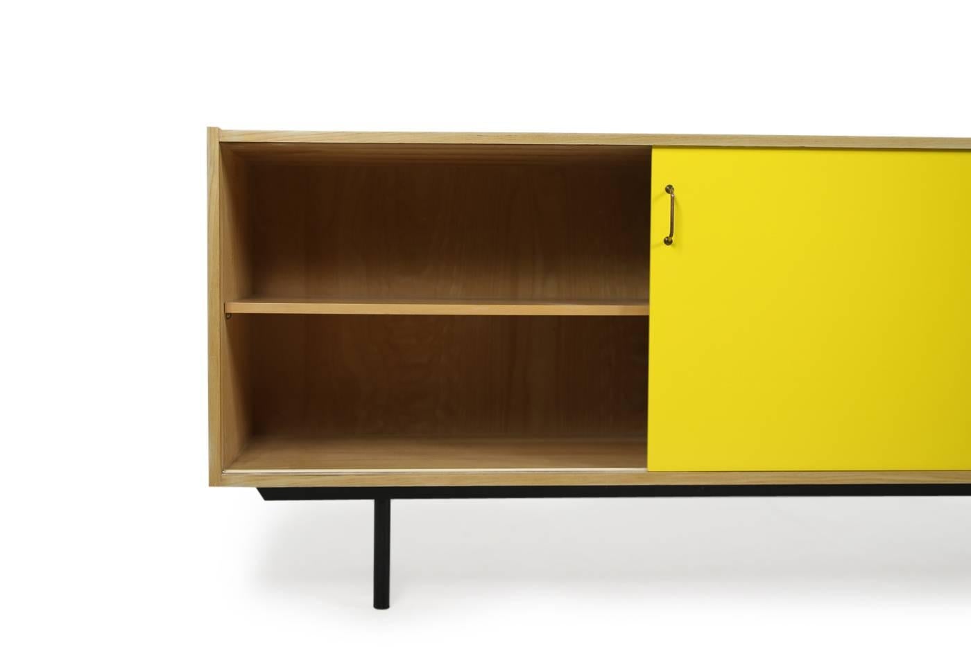 Beautiful and super rare Mid-Century Modern sideboard, 1950s Minimalist design, metal legs, yellow and white painted sliding doors with brass handles, four drawers, fantastic condition. Most likely a custom work or made to order object, never saw it
