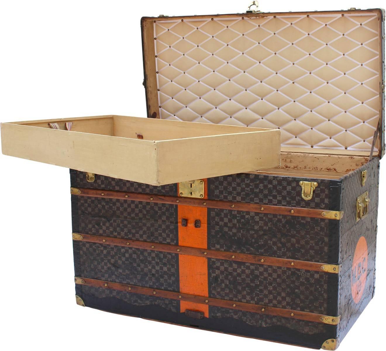 This large Louis Vuitton Damier trunk will make a bold statement in your home. Generally used as a coffee table or a blanket box at the end of a bed. With a distinctive orange stripe and MDC initials painted on the trunk alongside finishes such as