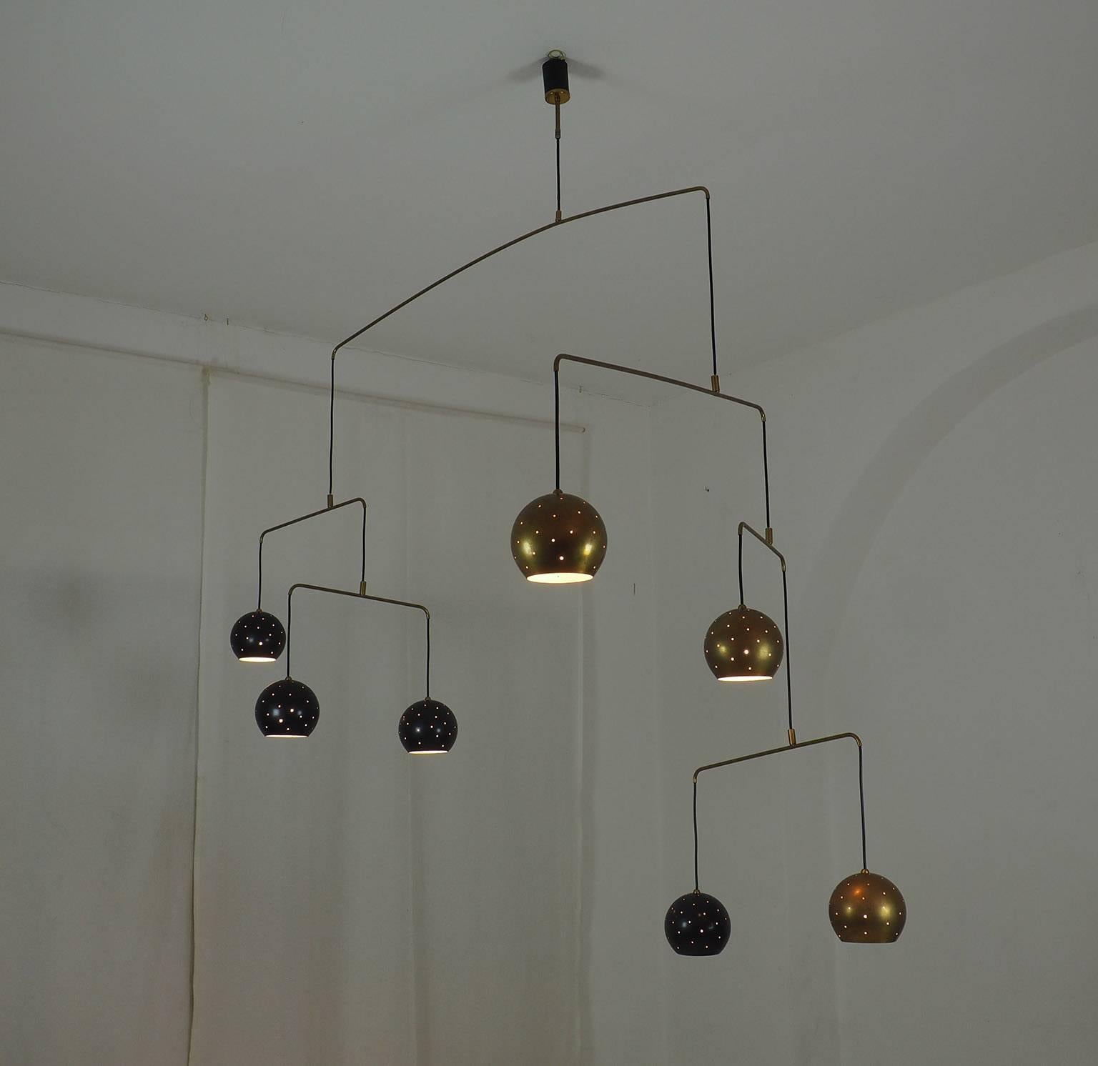 Original Italian brass mobile chandelier manufactured in a very small handcraft production in Milano.
Large, magic and poetical mobile chandelier with brass and black suspending spheres; it can moves with the flow of air.
Wholly in balance through