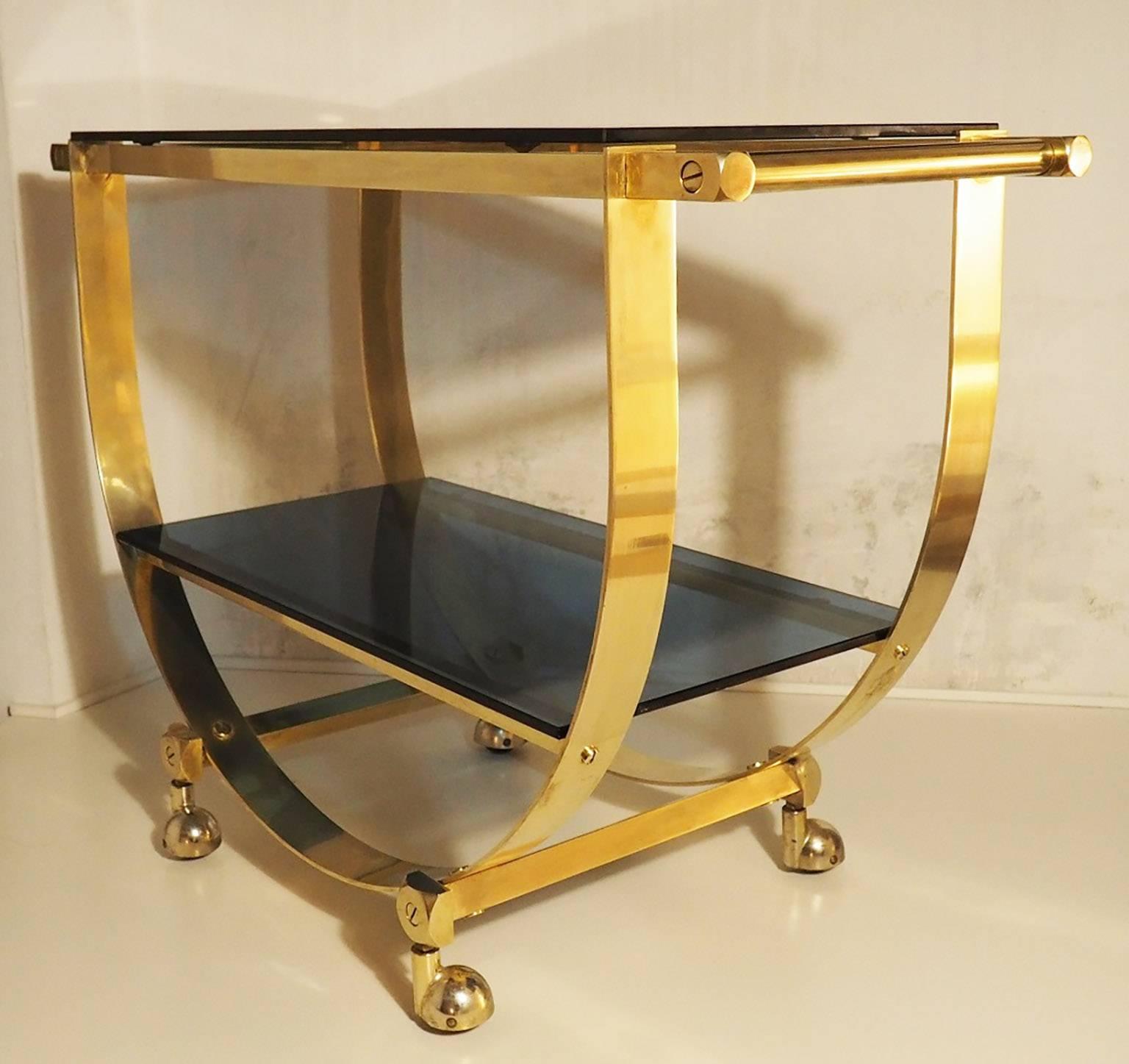 Glamorous table cart with nice brass structure and two blue glass shelves; a fine and functional design conceived and designed also to be easily removable. The two original blue shelves are in thickness glass; the quality of manufacture can be