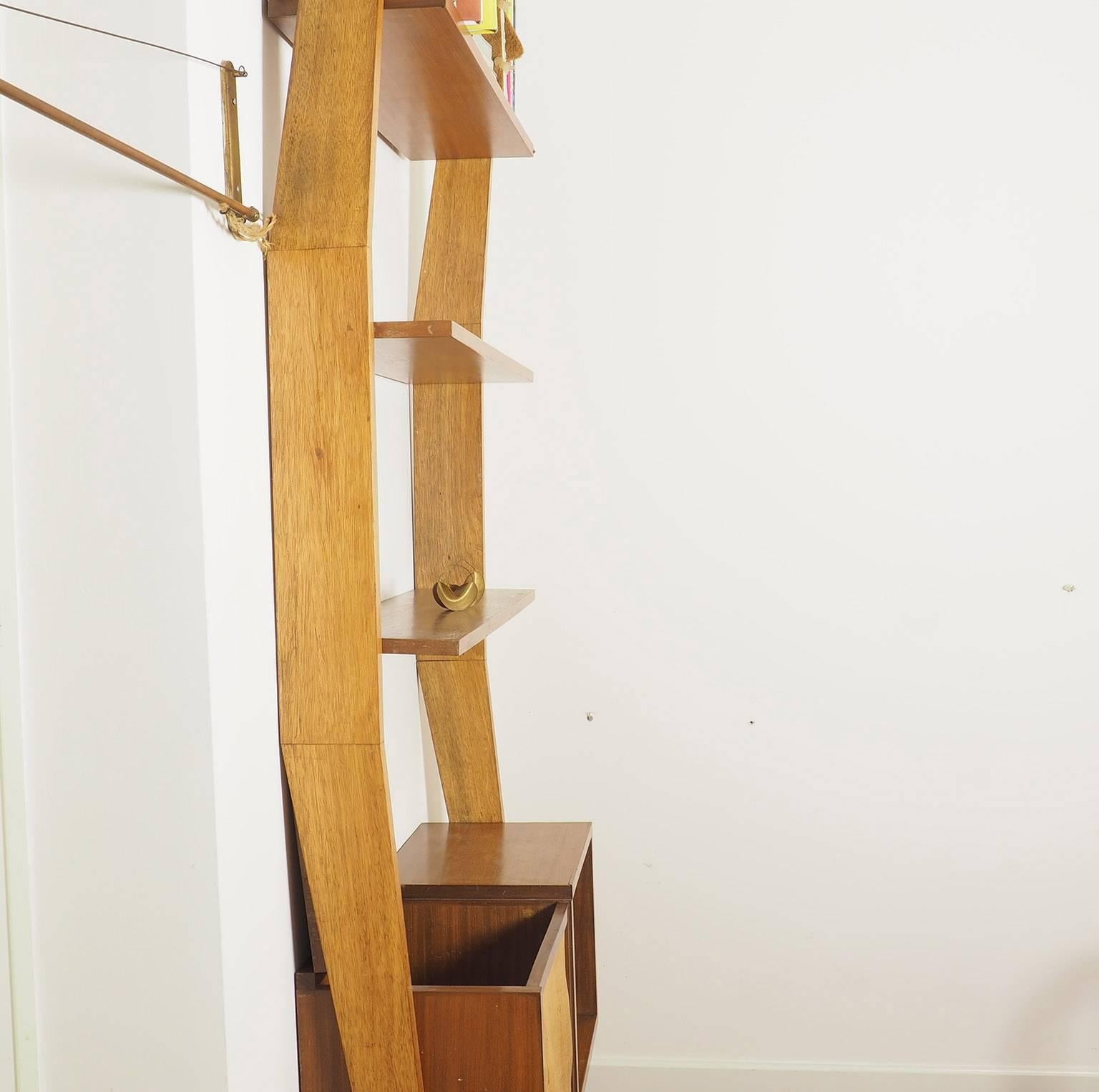 A particular shape for this Bookshelf with brass adjustable feet designed by the architect Augusto Romano in 1950s.
It can be used also as a room divider or simply as a wall bookshelf. Better.
The lower body has two compartments one closed and