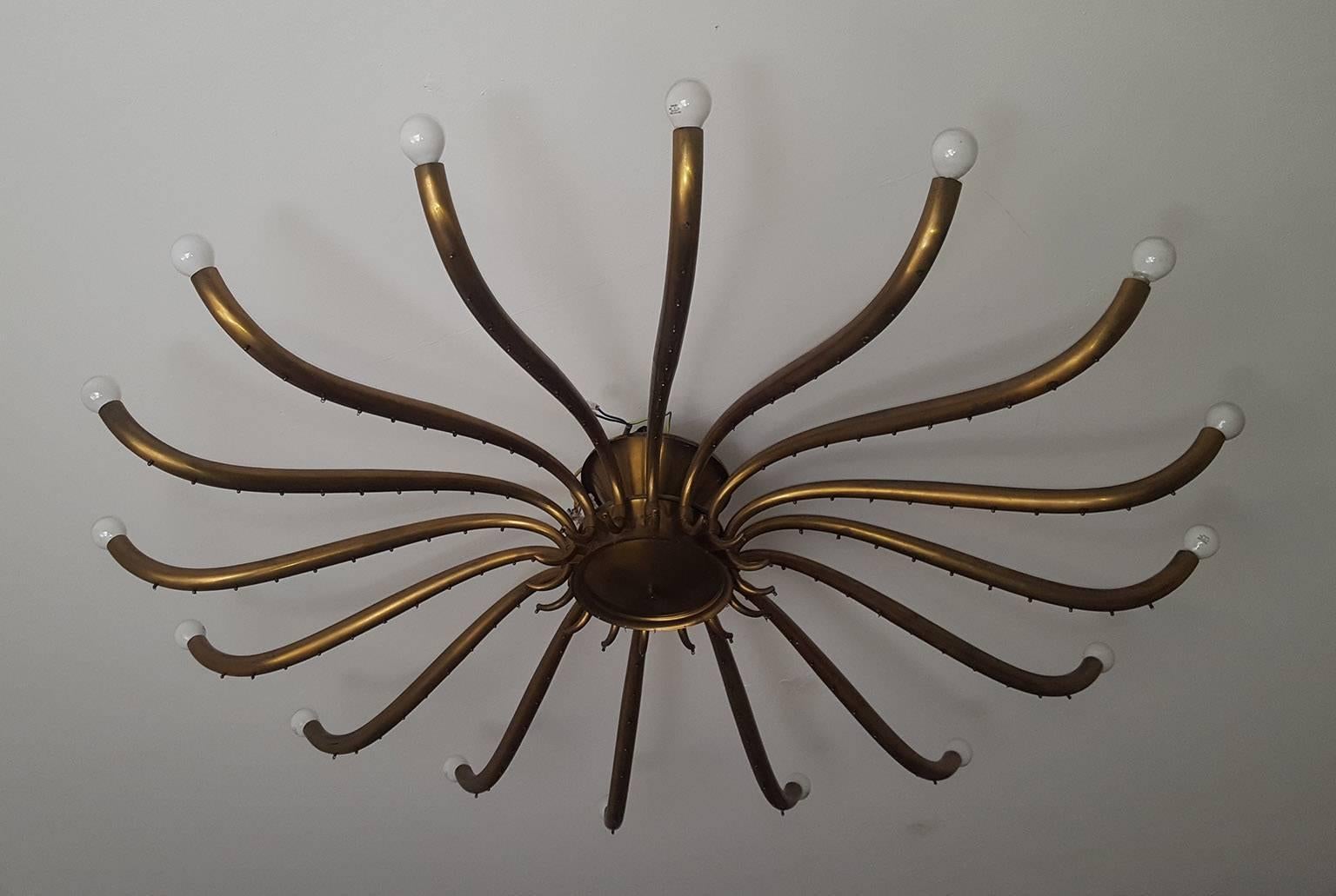 A large Italian chandelier, entirely in brass with 16 long arms in the Guglielmo Ulrich style, made in circa 1950. In Milano.
A good quality with a nice patina too.
Measure: Diameter 135 cm.
 