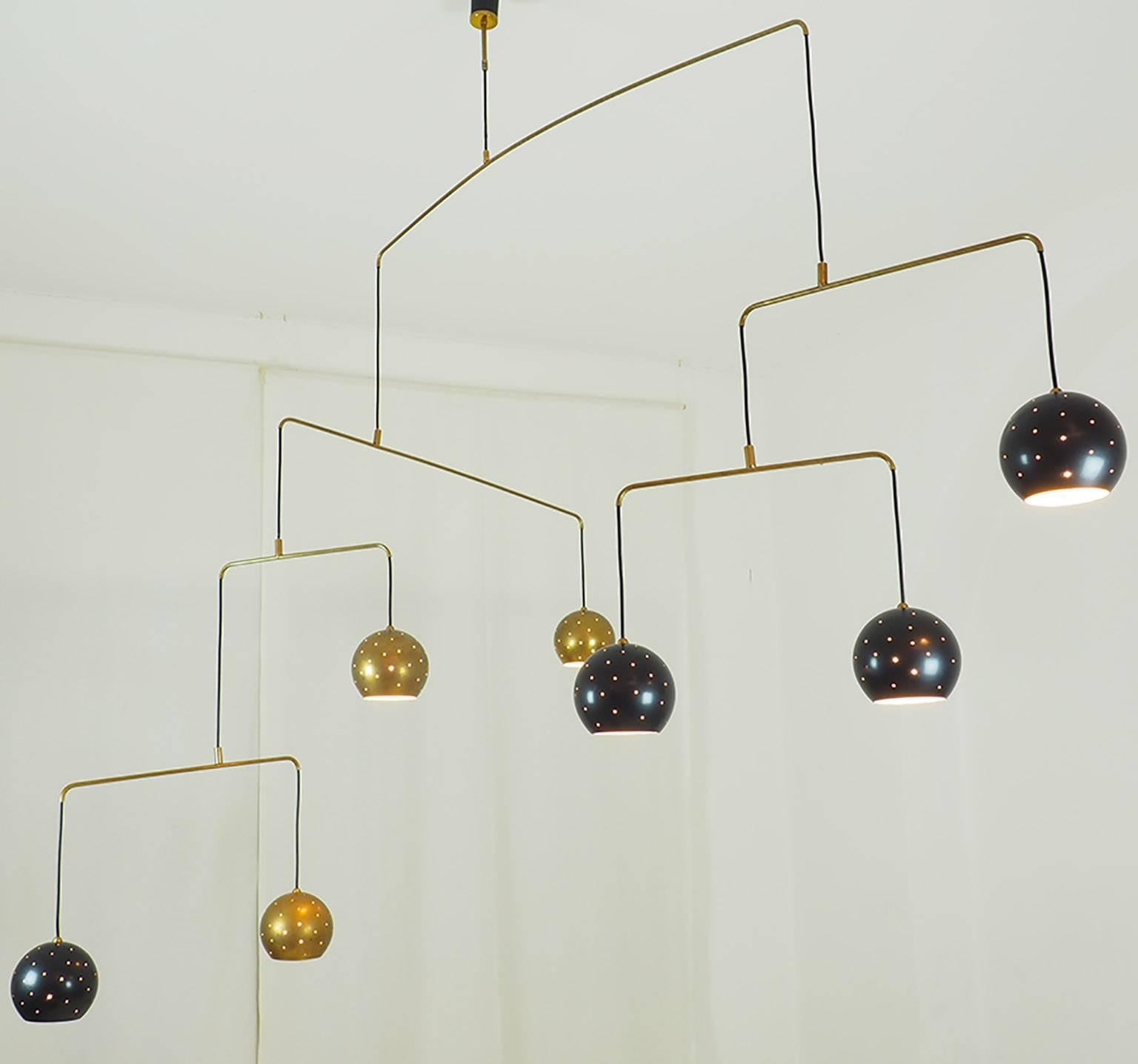 Original vintage  brass Mobile chandelier .
Large, magic and poetical mobile chandelier with brass and black suspending spheres; it can move with the flow of air.
Wholly in balance through its thin brass arms and the interaction of the weights of