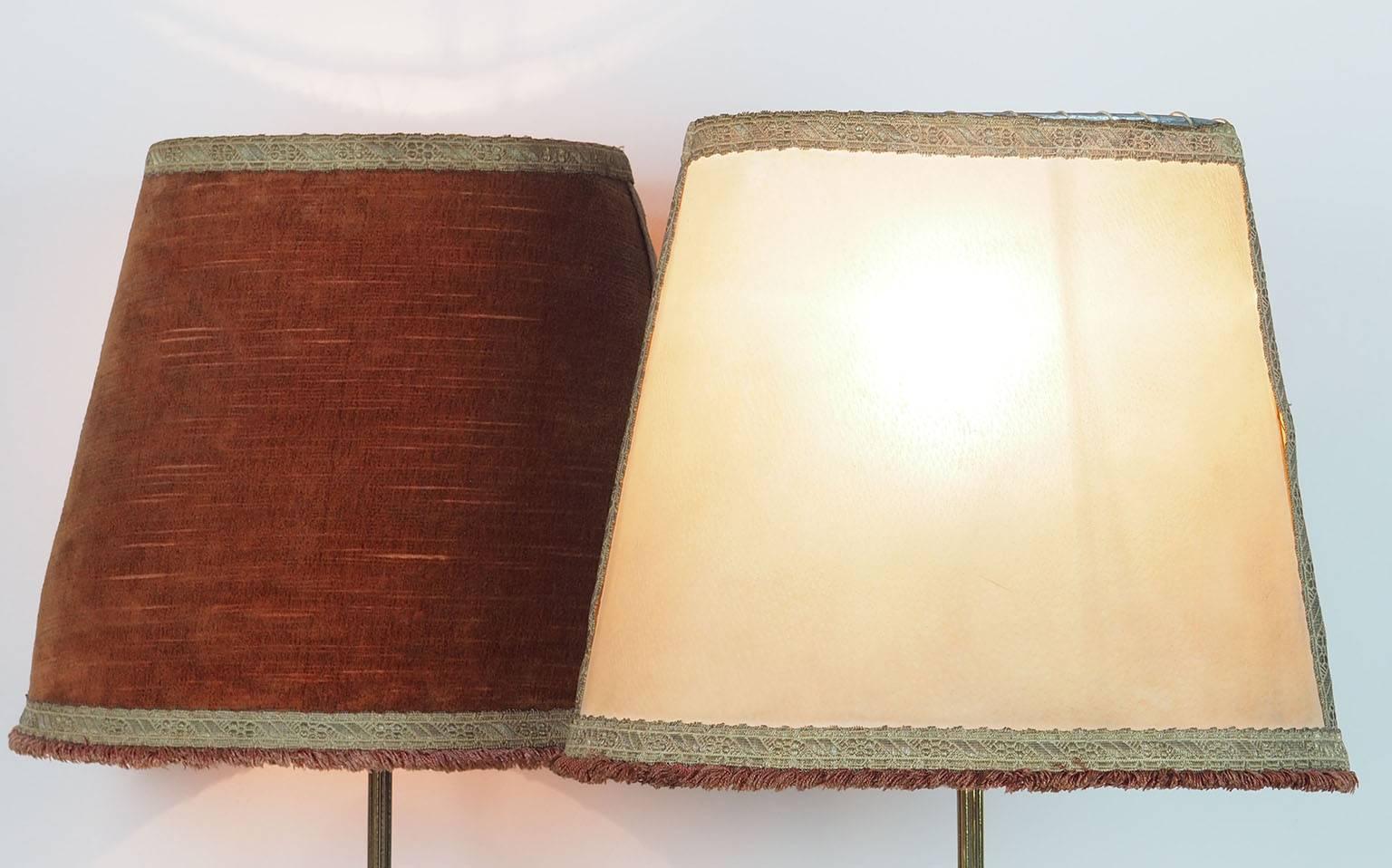 Large ( height 75 cm) couple of  brass table lamps with original Oval lampshades manufactured by Chiarini in 1950s.
The original Bifronte parchment and velvet lampshade has a particular elliptical shape.
They can be easily re done.
The thinness of
