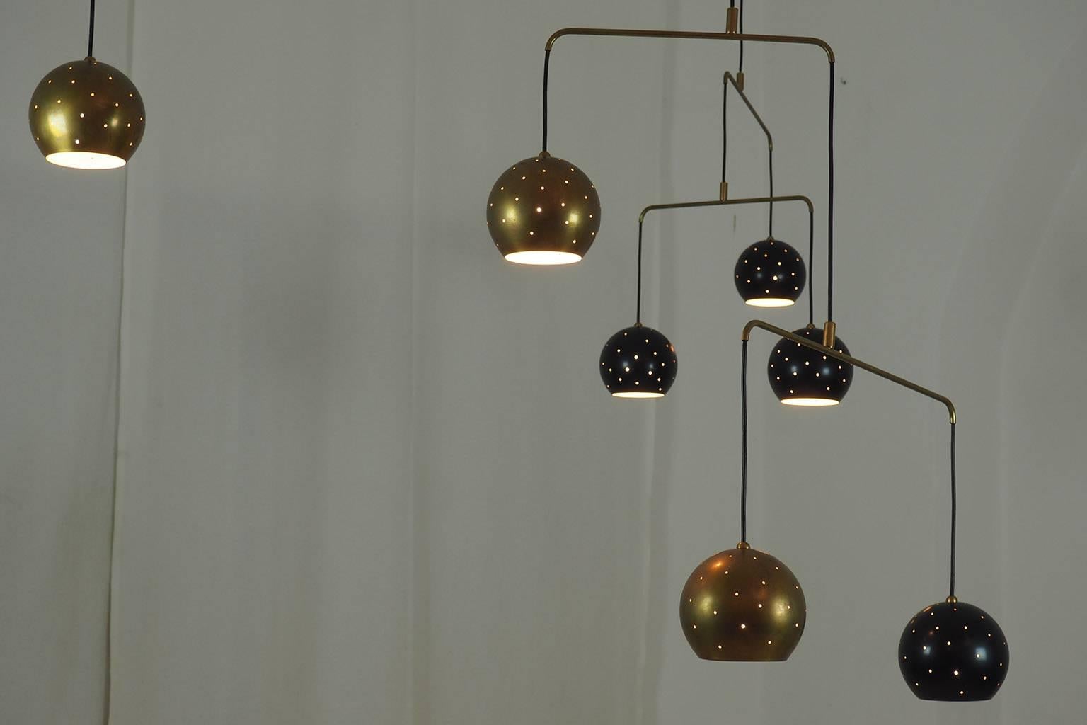 Original vintage Italian brass Mobile chandelier.
Large, magic and poetical Mobile chandelier with brass and black suspending spheres; it can move with the flow of air.
Wholly in balance through its thin brass arms and the interaction of the