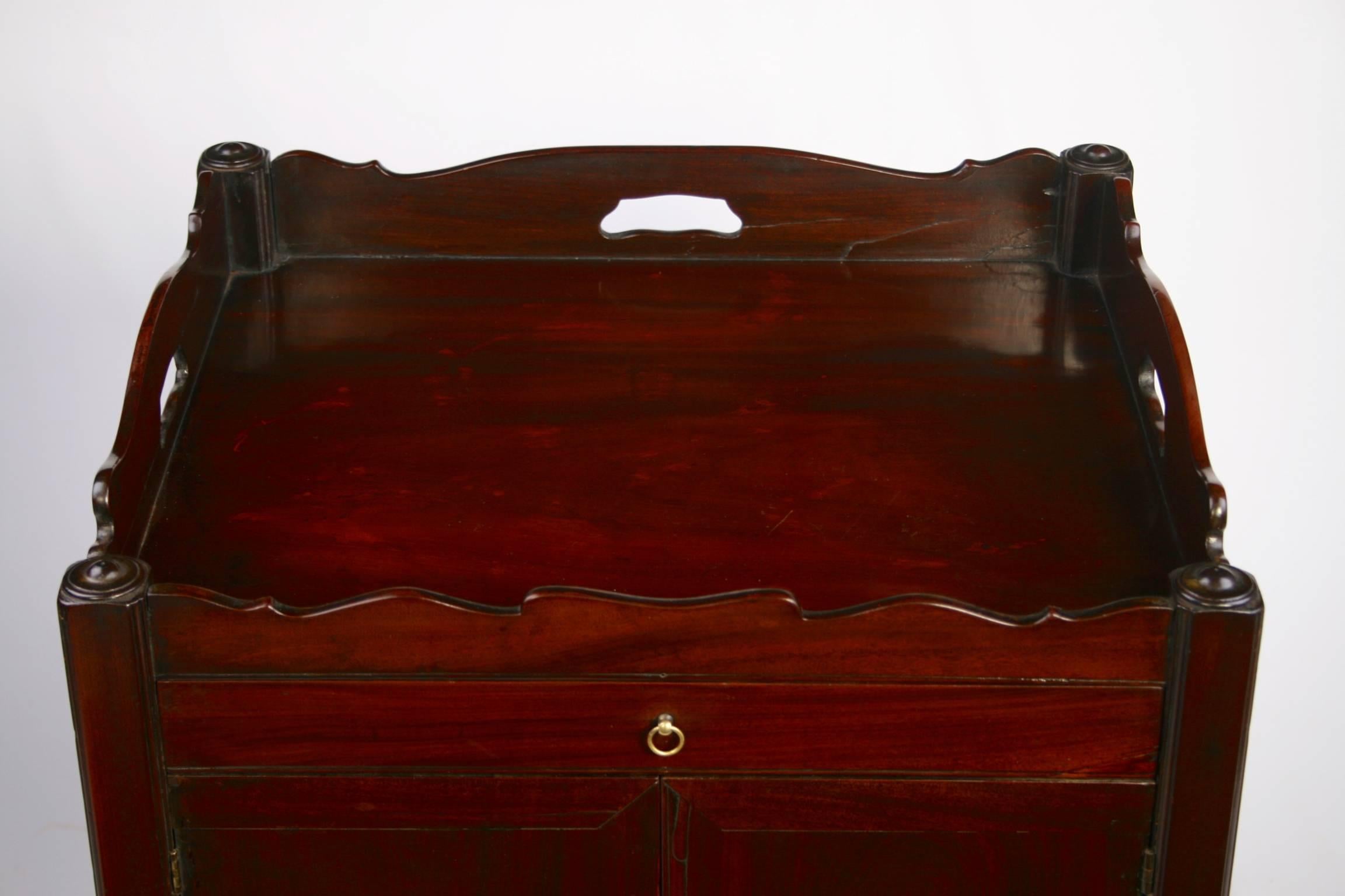 A mid eighteenth century night table contructed from excellent quality mahogany. Having a shaped gallery tray top above a straight front fitted with a single drawer and above two hinged doors. The base consists of a pull out drawer with a boarded