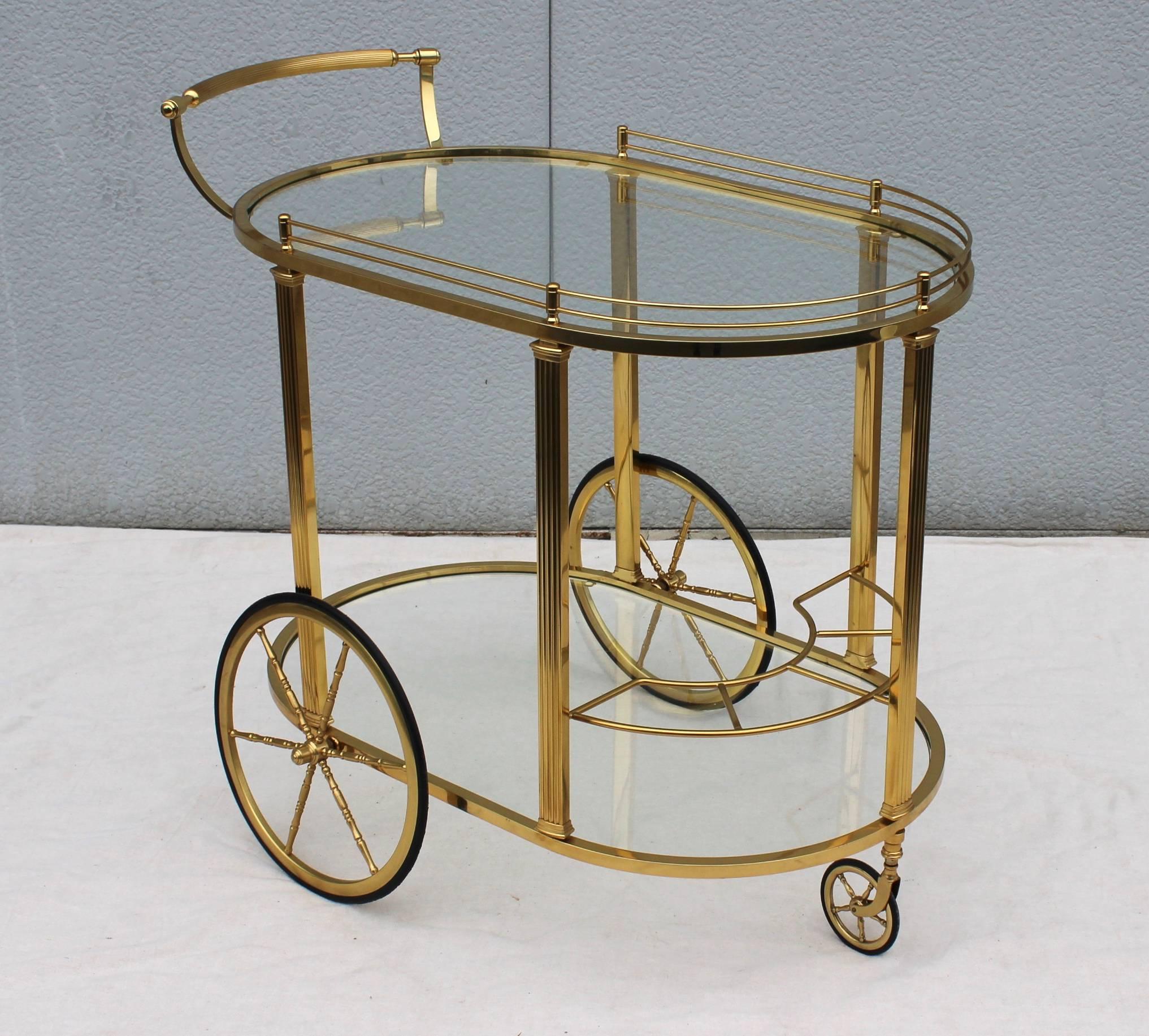 Stunning 1950s modern two-tier Italian brass bar cart with bottle holder.

Height including handle 31''.