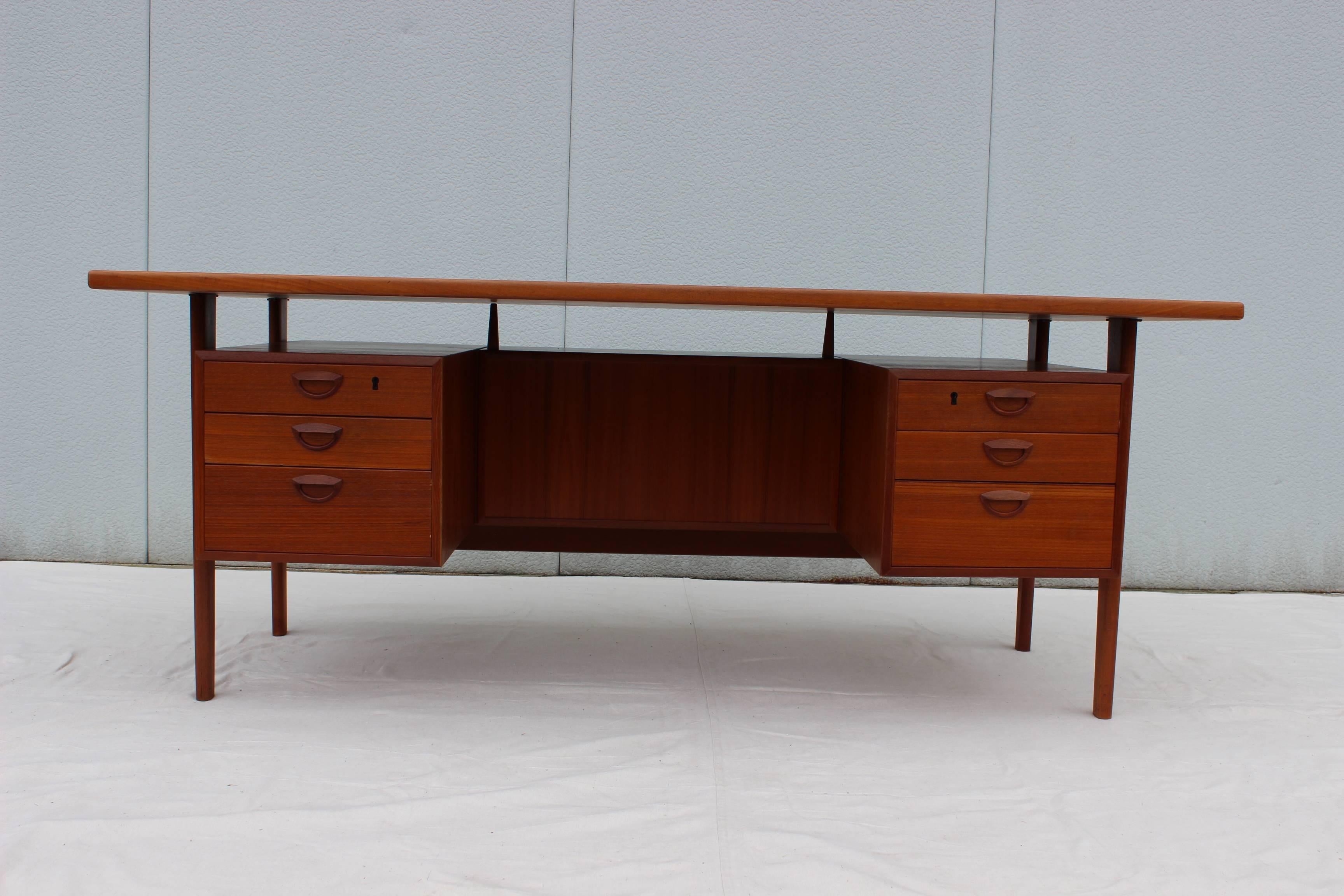 Stunning 1960's Large Kai Kristiansen for Feldballes Mobelfabrik floating top Teak executive desk. with six drawers two of them with locks and 3 back shelves two with doors and locks and 1 open shelf, this desk was purchased from the original owner