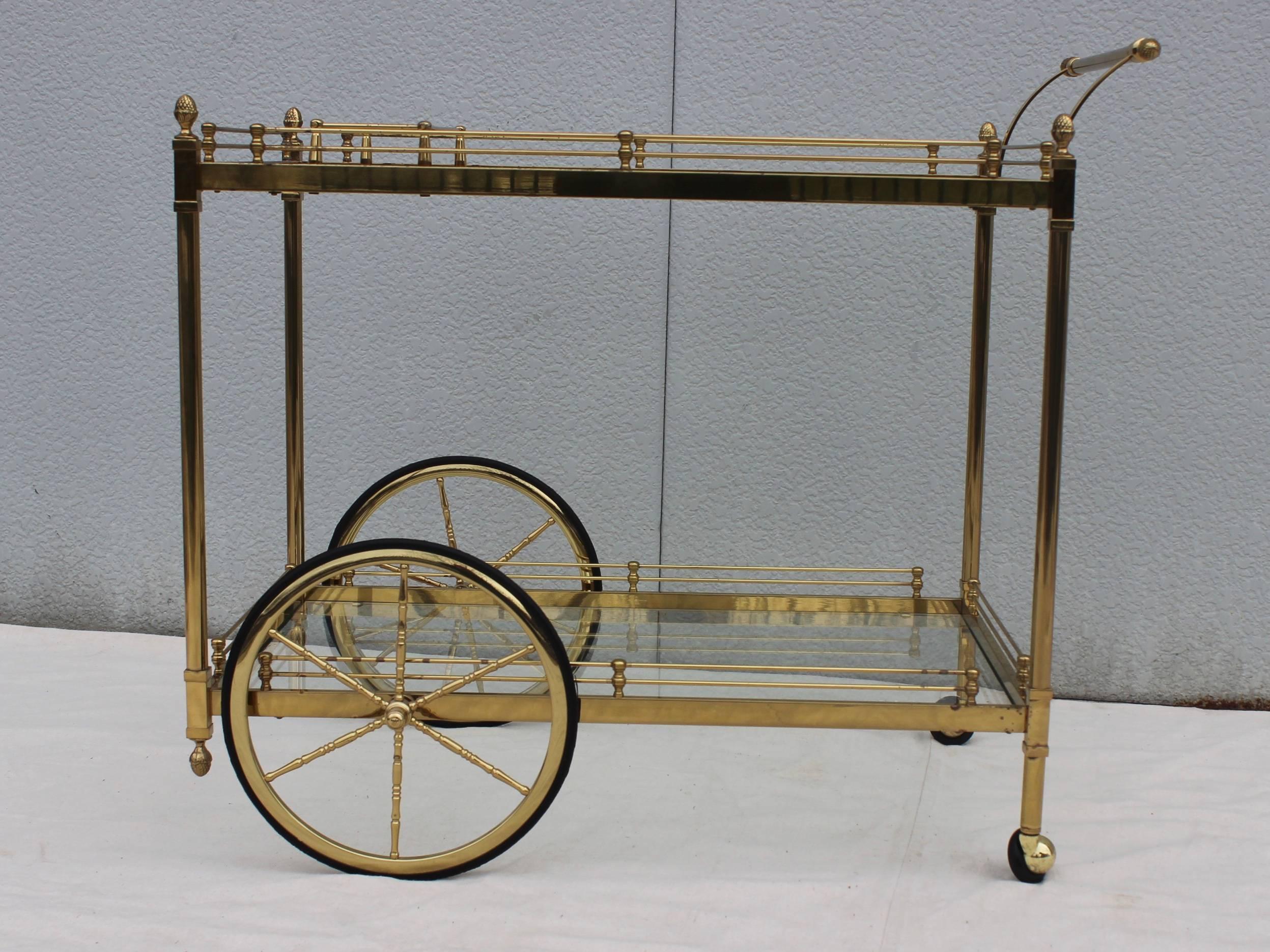 1950s Modern two tear Italian brass rolling bar cart with bottle holder.

Width and height includes the handle.
Height without the handle 26''. 
Width without the handle 30.5''.
