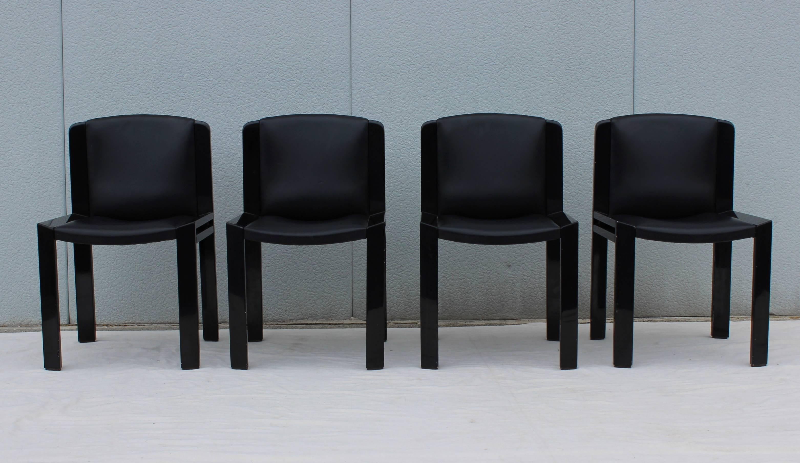 Set of four Joe Colombo For Pozzi model 300 dining chairs, black leather upholstery and lacquered wood frames.