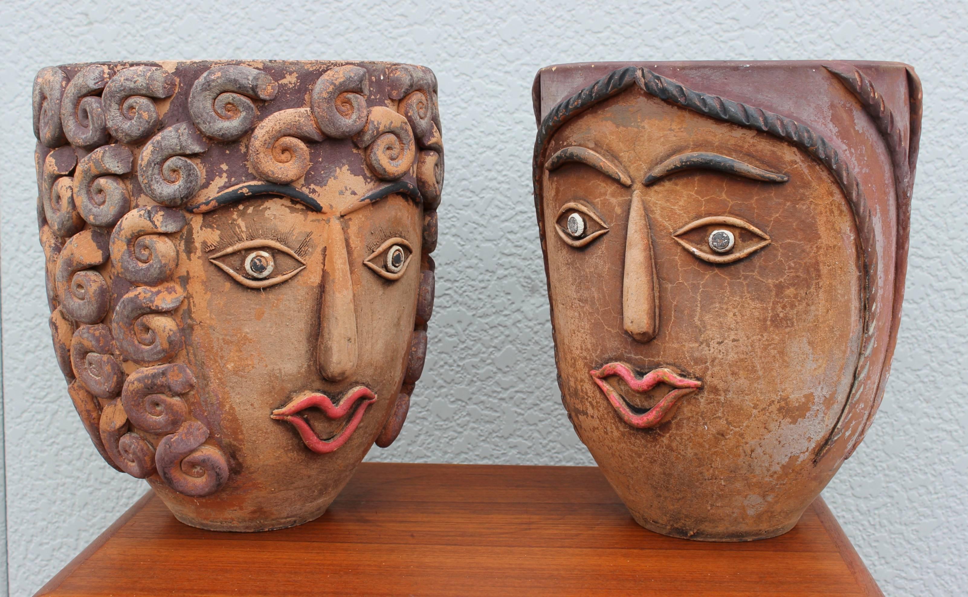 1960s Mexican terra cotta face planters, one of them has a face to each side.

One of the planters is slightly smaller.

Diameter 11.5'' height 13.75''.