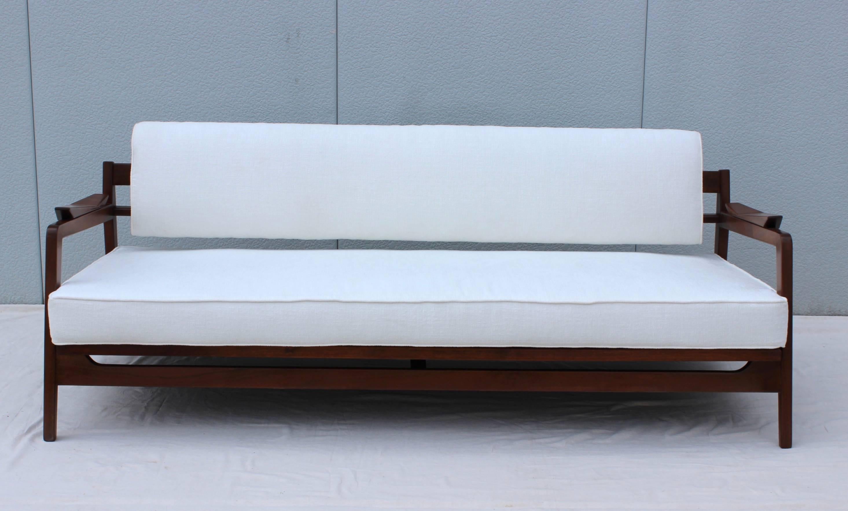 Stunning 1960s Jens Risom solid walnut daybed newly upholstered in Kravet white fabric, with pull-out mechanism to adjust to an even position.