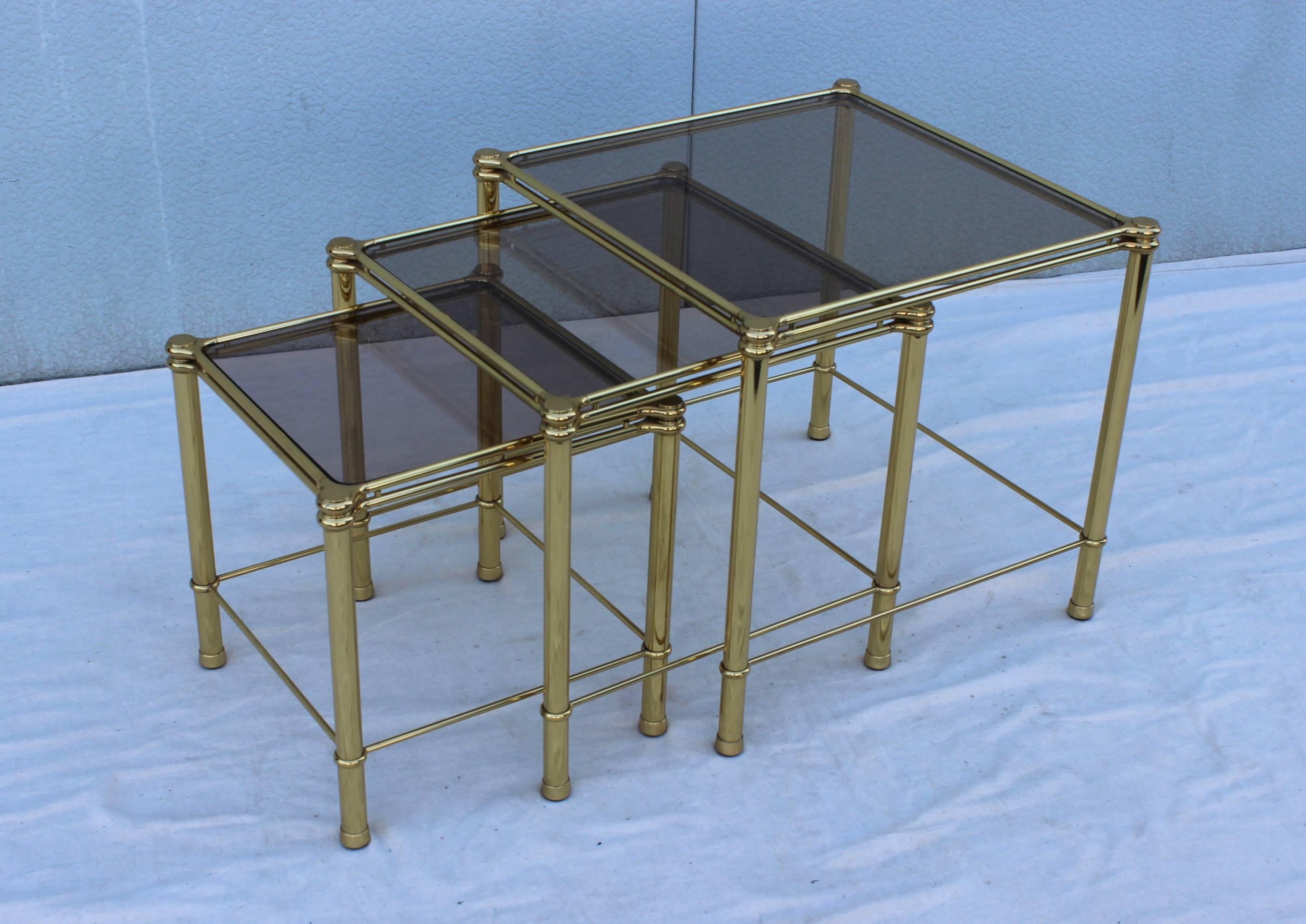 1960s modern Italian brass and glass nesting tables, in vintage original condition with minor wear and patina due to age and use, these pieces are well made and heavy. 

Medium table width/depth 18'' height 17''.
Small table width/depth 15'' height