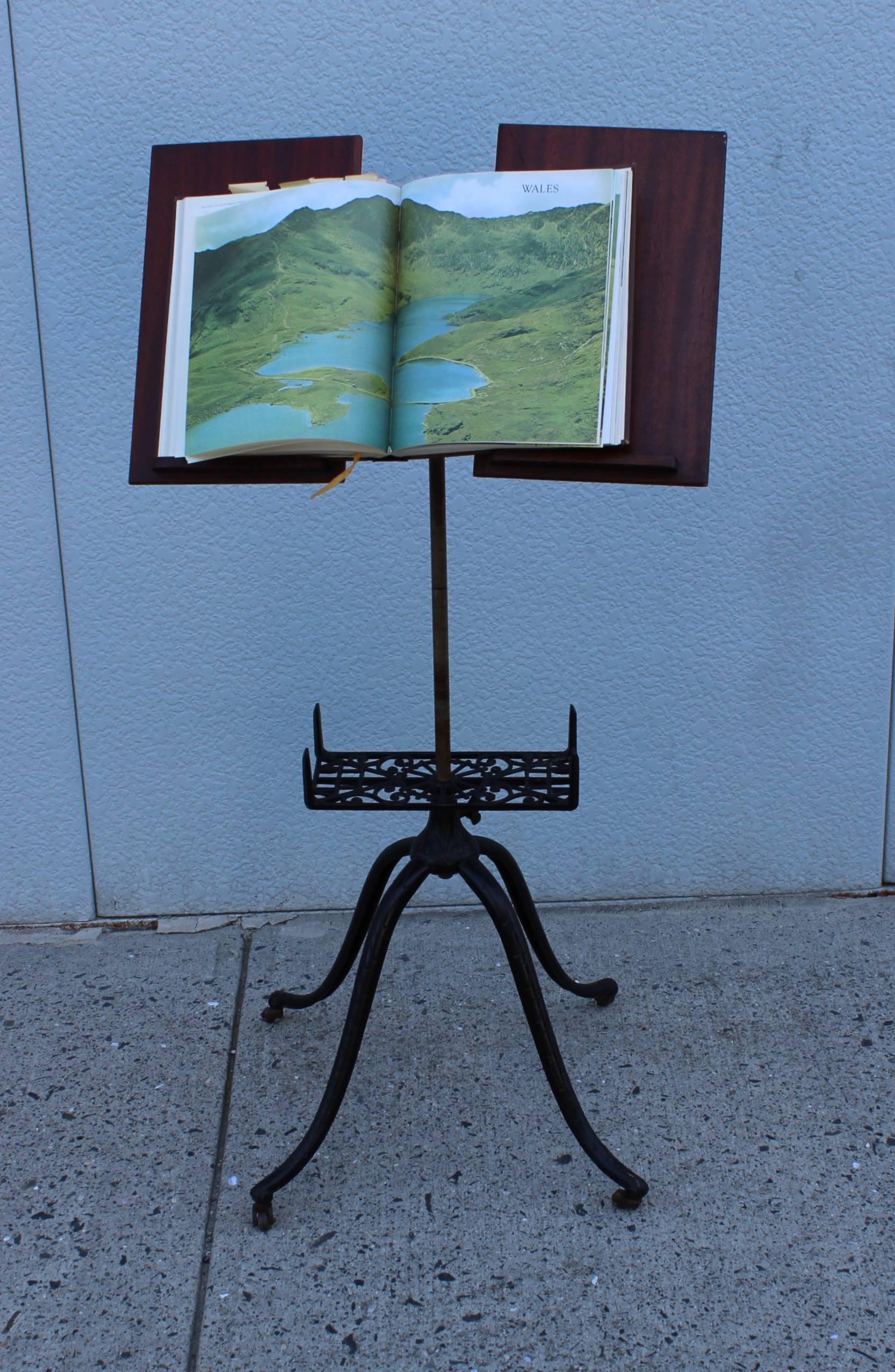 1930s adjustable height cast iron library stand, with articulating mechanism and book holder.