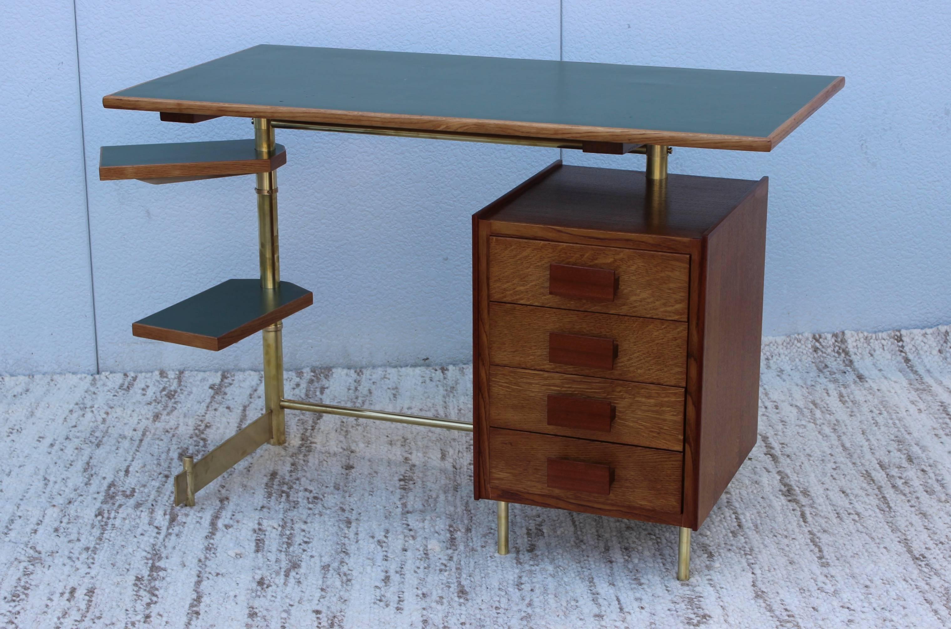 Stunning 1950s modern Italian desk made of oak and teak with brass frame. Four drawers with teak handles and linoleum top, the two trays which swivel 360 degrees.