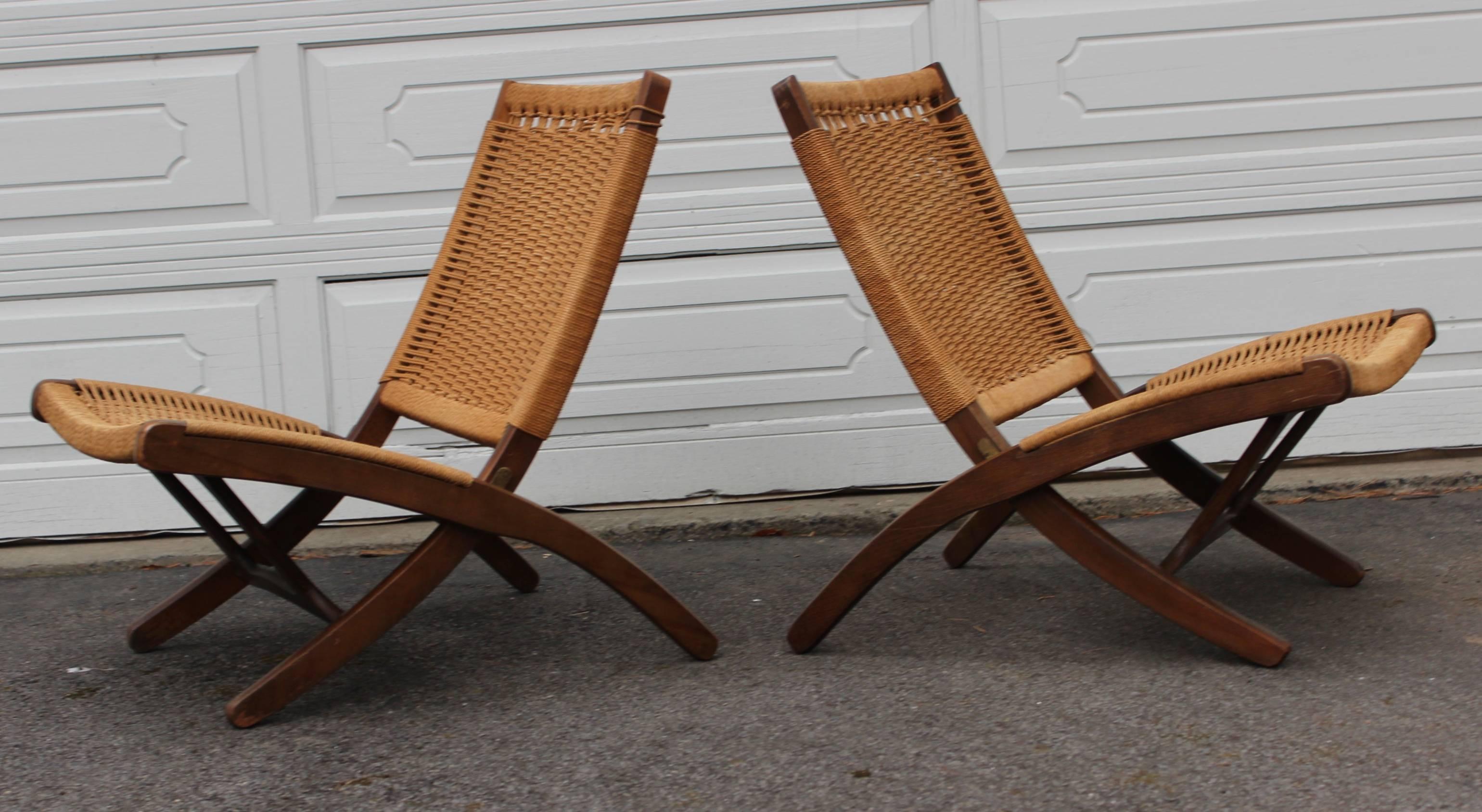 Stunning pair of 1960s Hans Wegner style, folding walnut and rope lounge chairs.